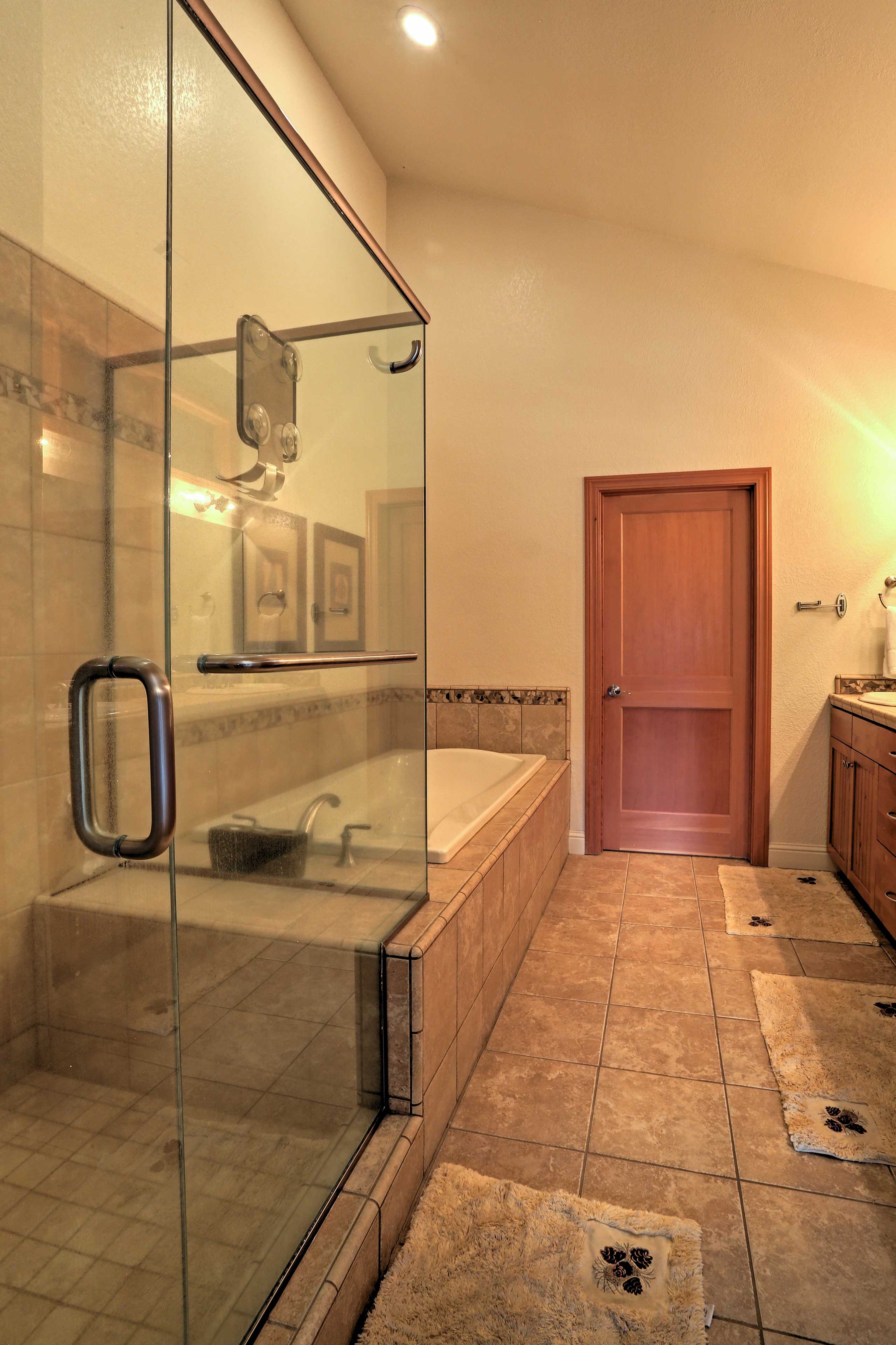 This pristine en-suite bathroom features a large walk-in shower and separate soaking tub.