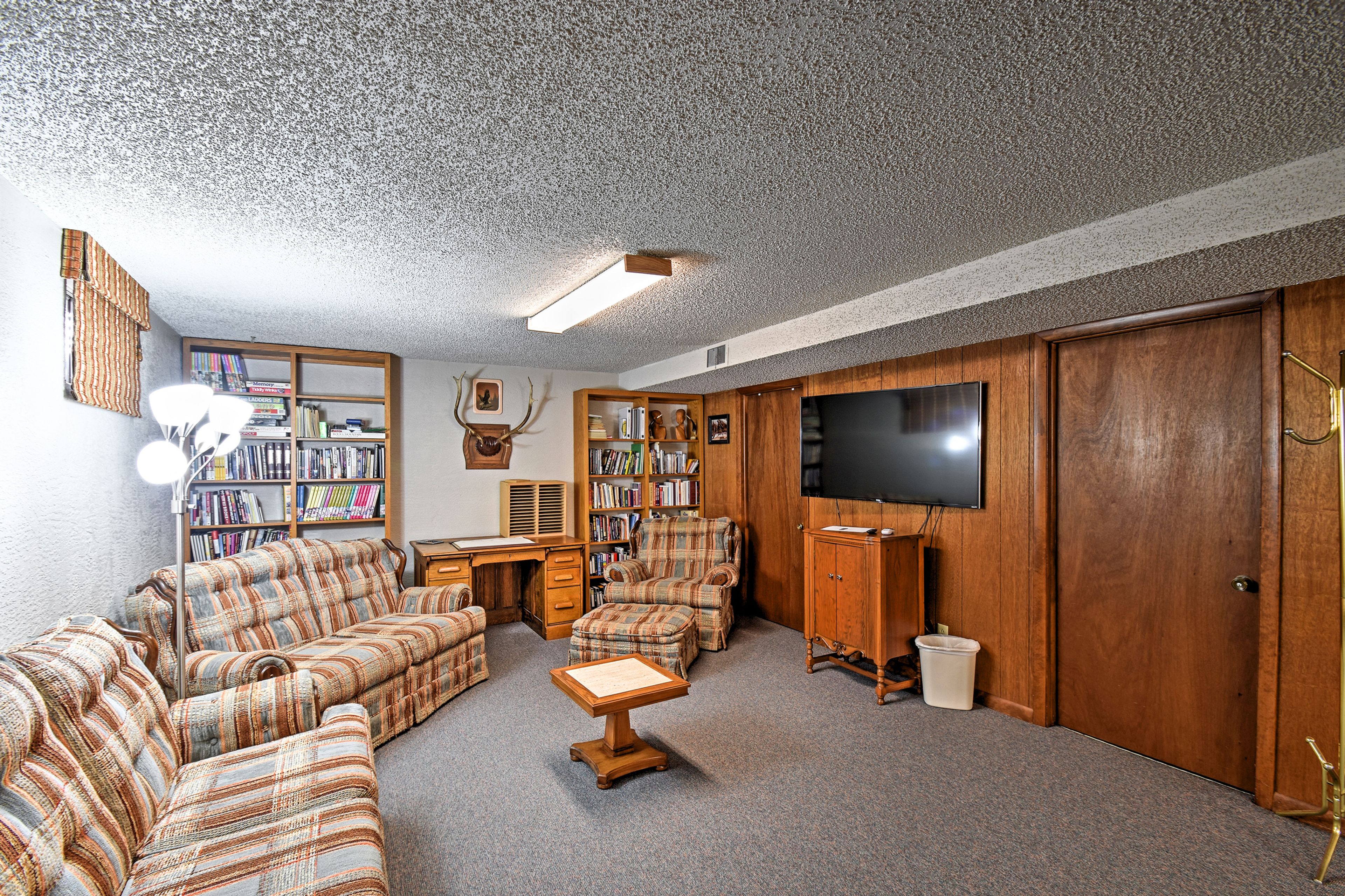 The downstairs recreation room has a TV, couch, books and a ping pong table.
