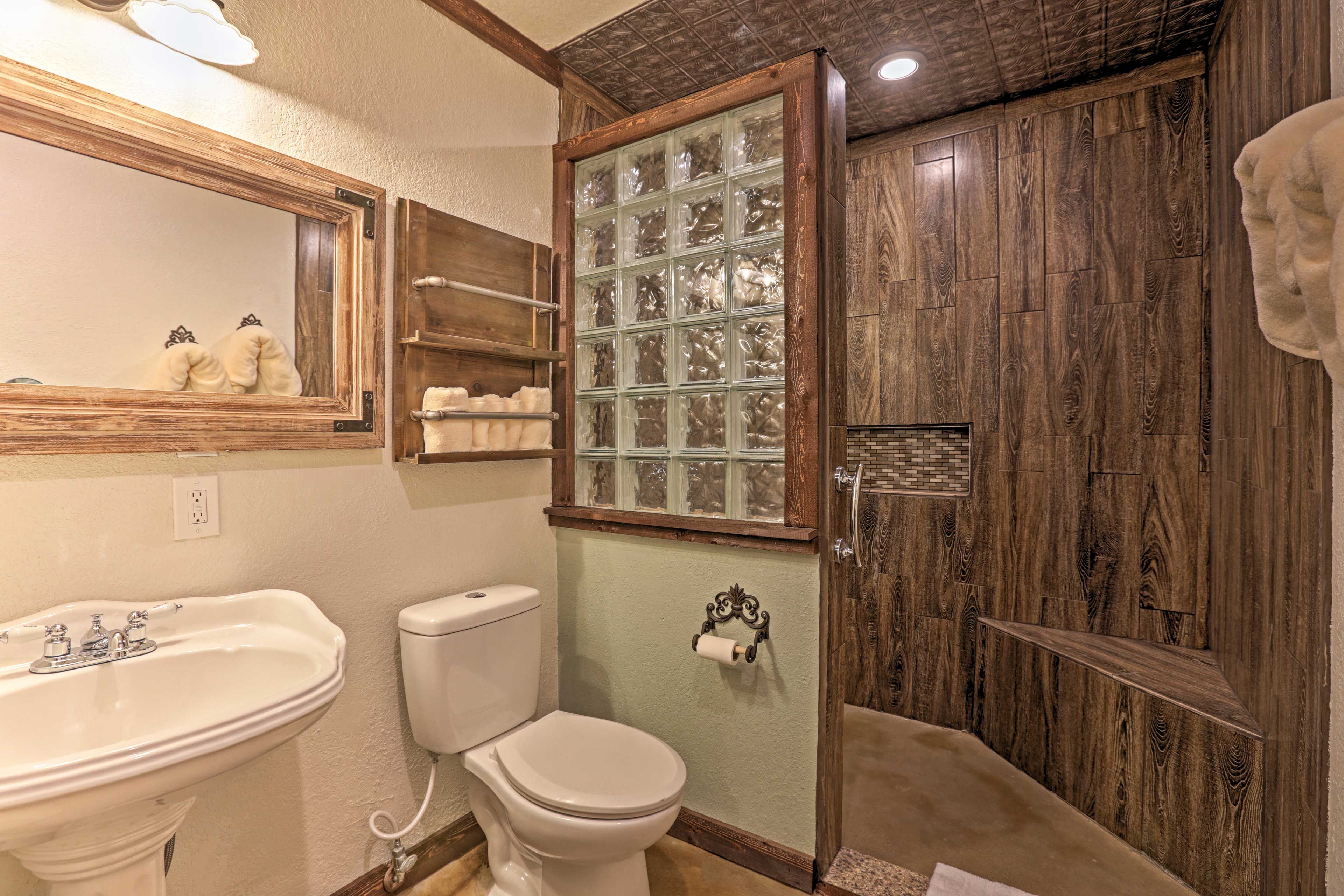 The bathroom features a walk-in tile shower with rain head and custom fixtures.