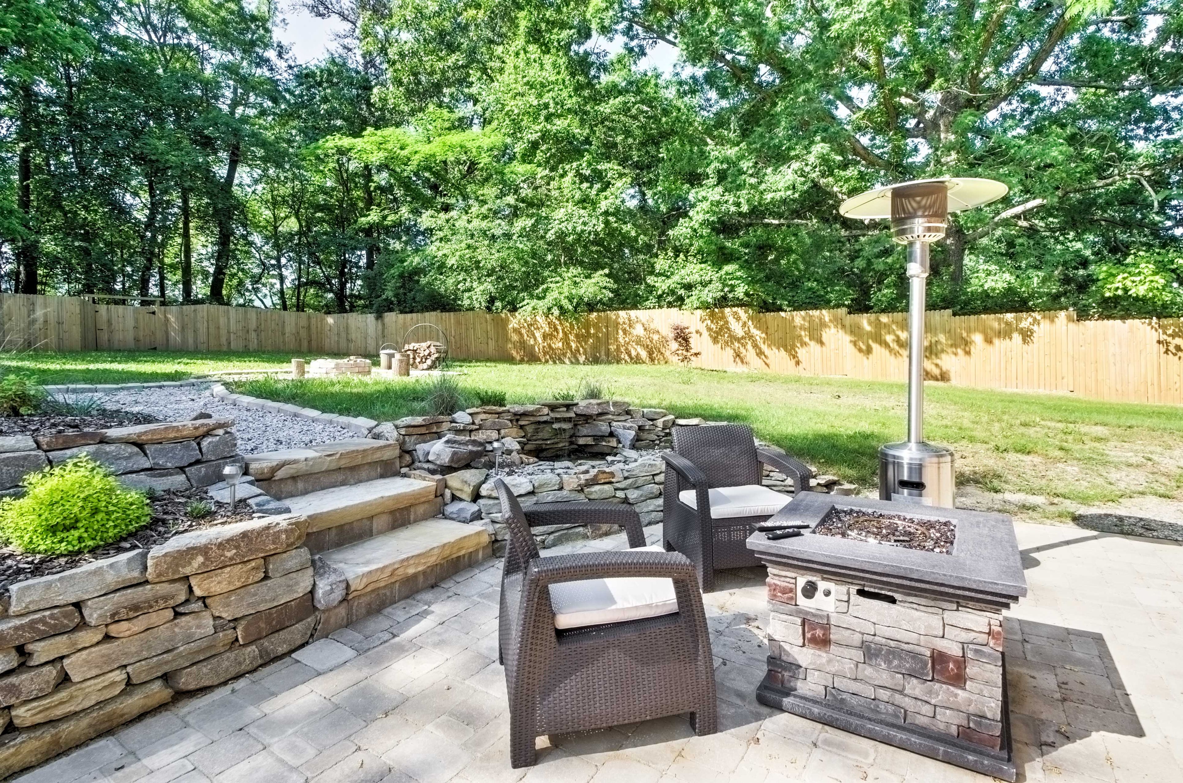 The spacious and manicured yard offers a great seating area, outdoor fire pit and sauna.