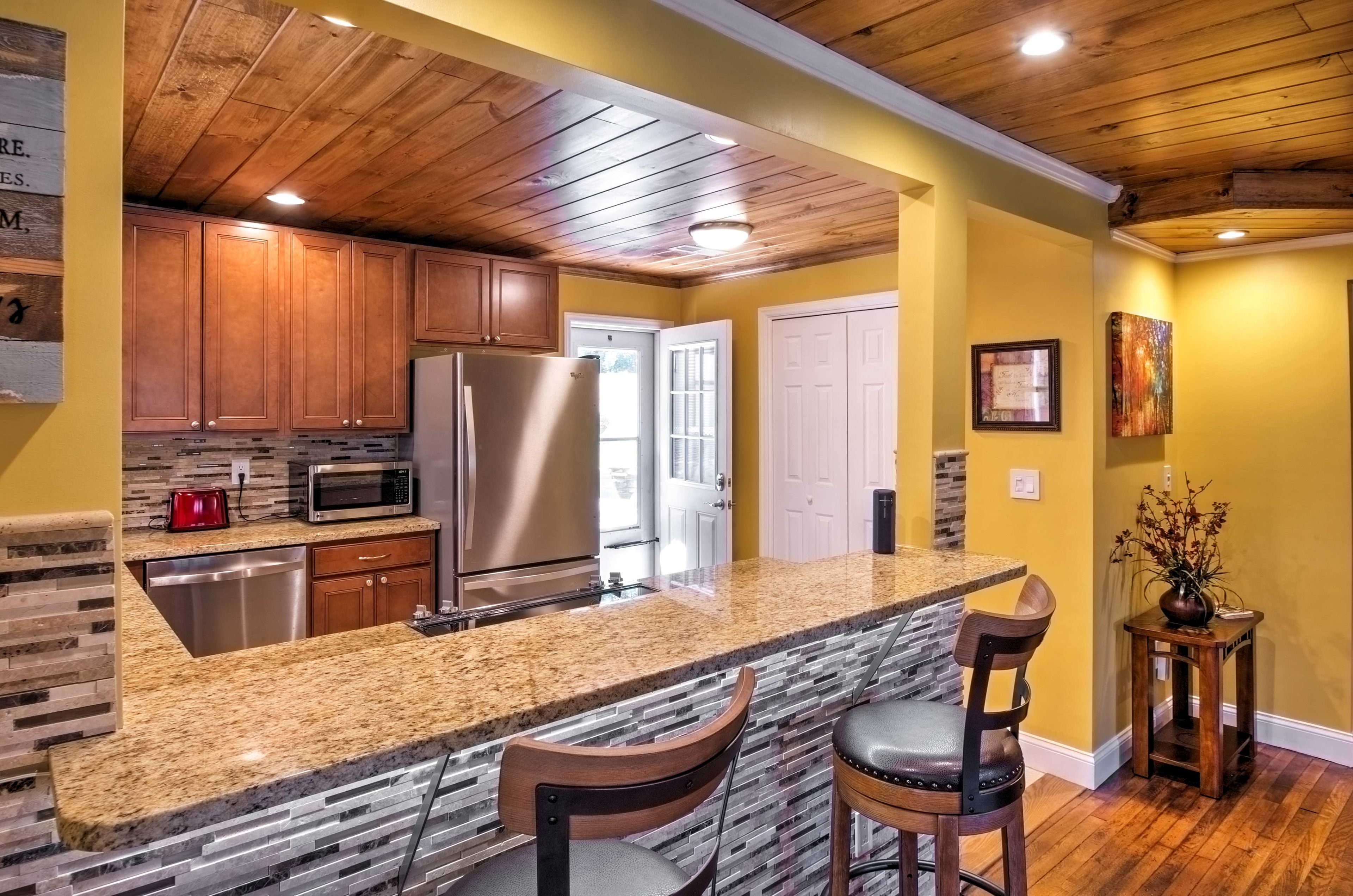 The updated kitchen features stainless steel appliances, beautiful wood cabinets and breakfast bar.
