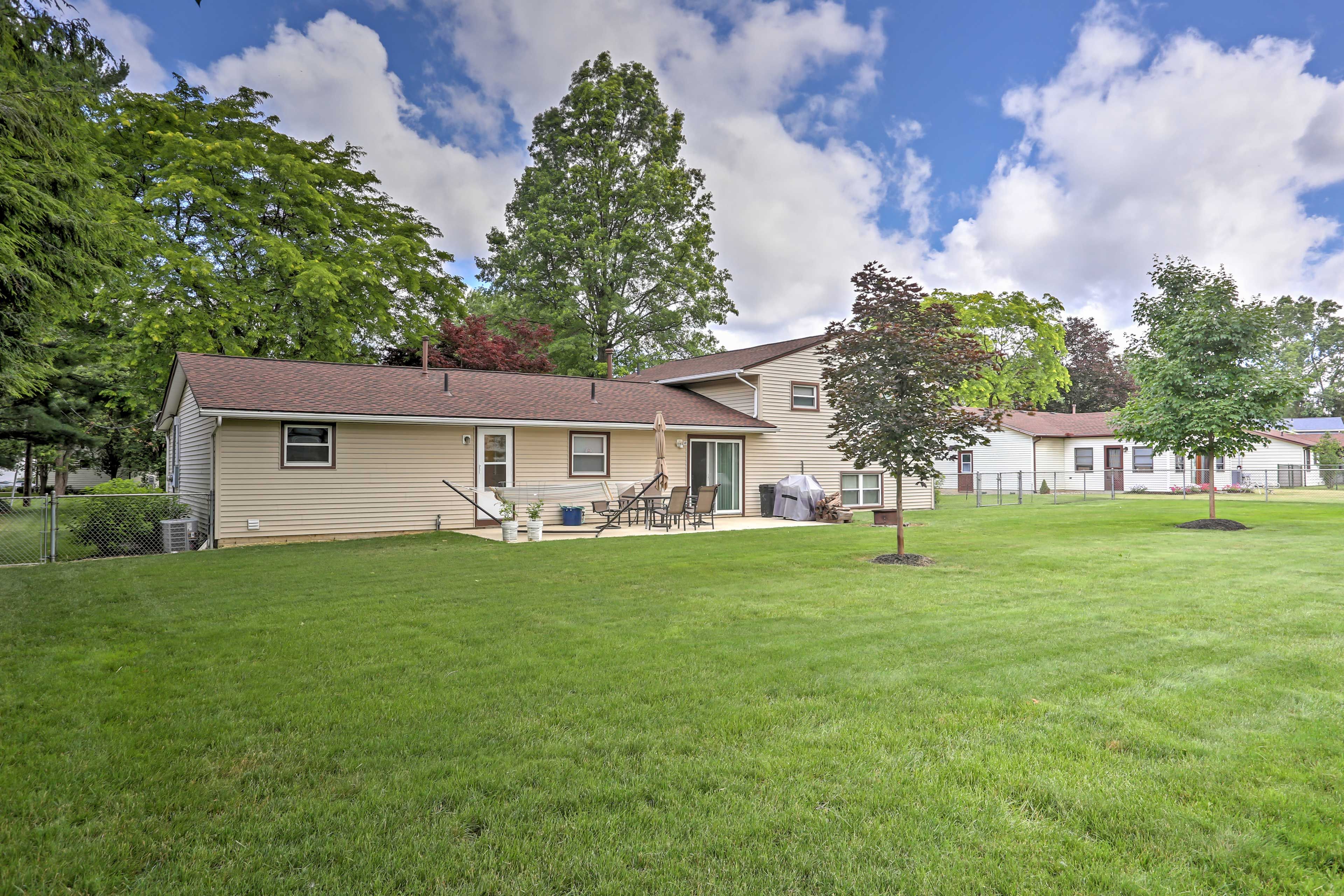 The fenced-in backyard has lush green grass.