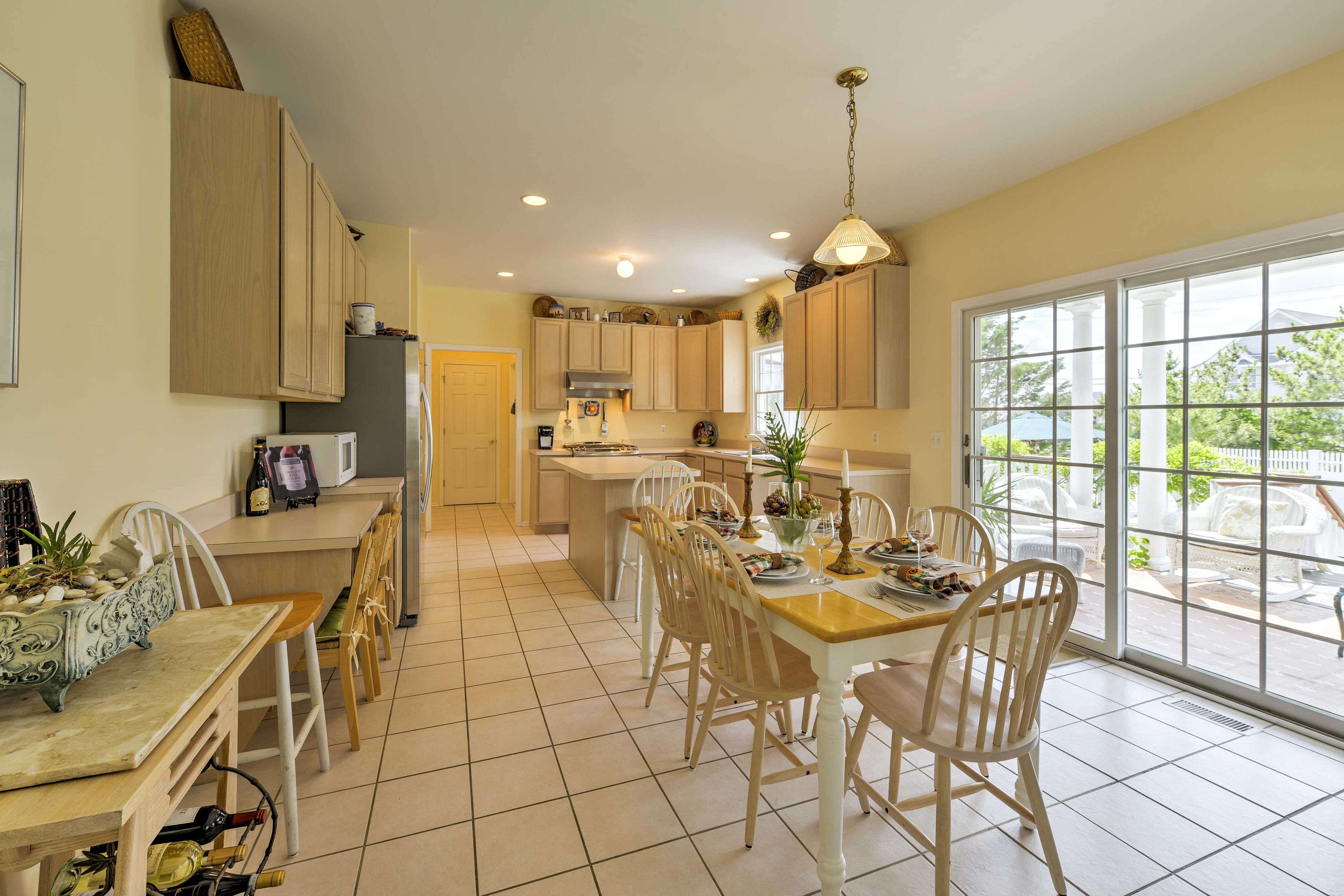 The dining table is set for 6, with additional seating at the island bar top.