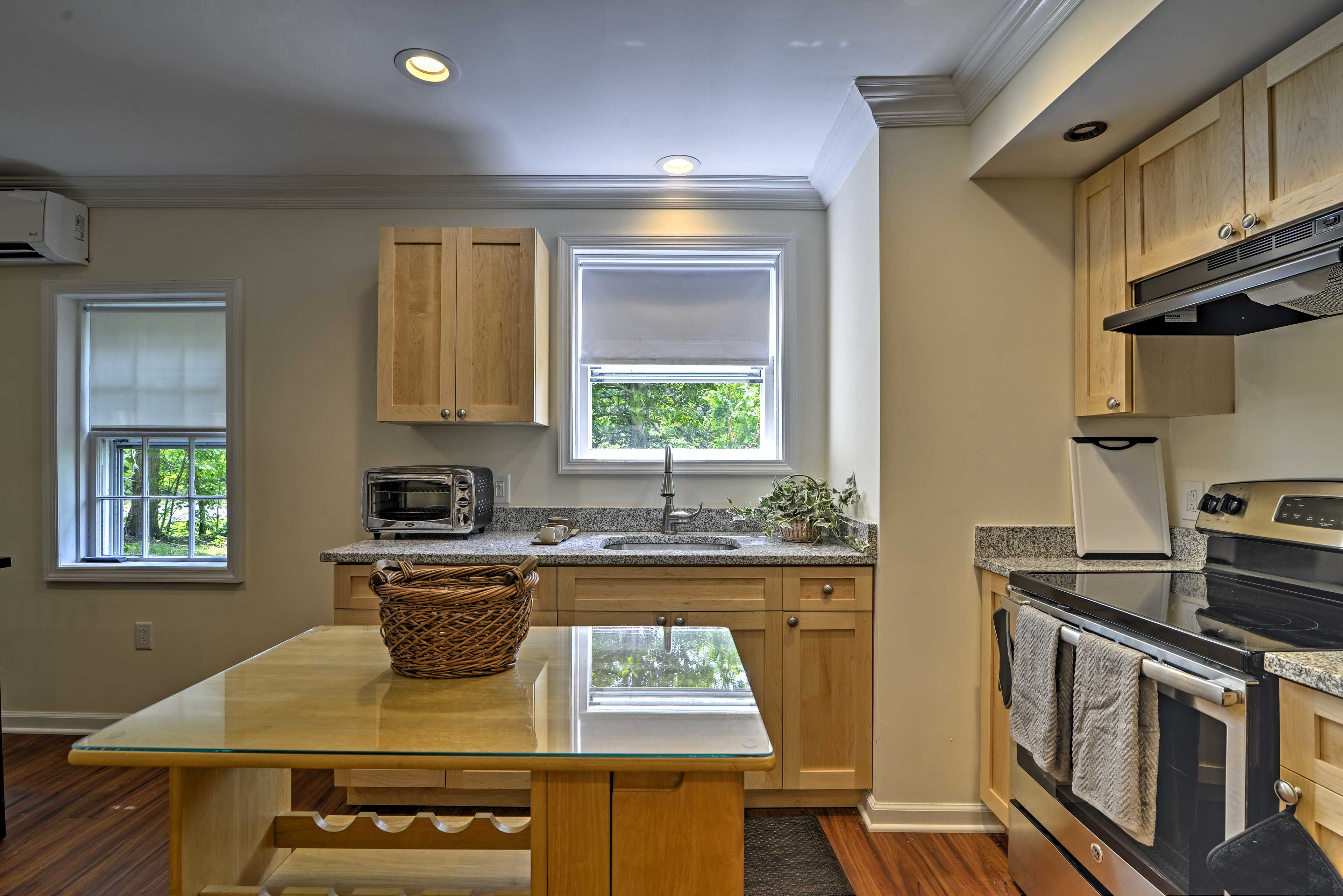 The kitchen features stainless steel appliances and a quaint center island.