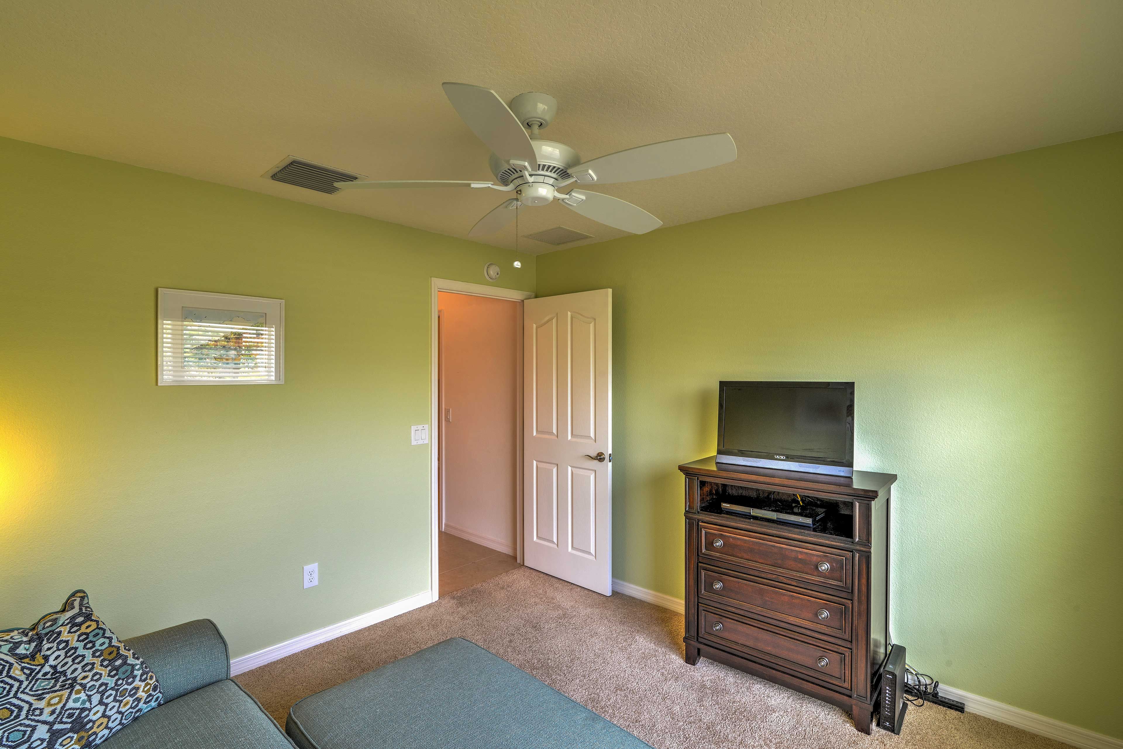 The den includes a sofa and a flat-screen TV.
