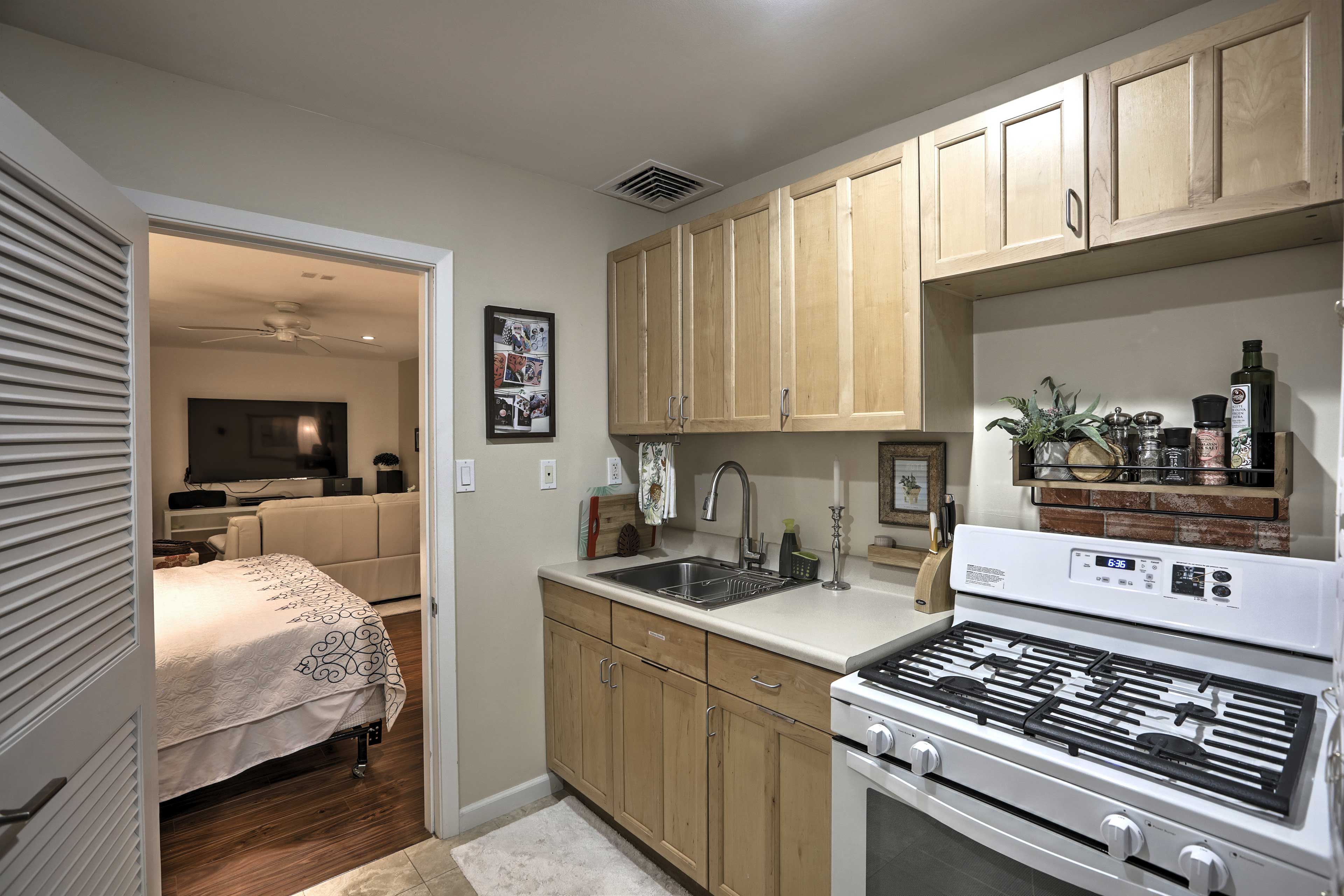 Prepare hearty meals in the well-equipped kitchen, which features a gas range oven, microwave, tea kettle, coffee maker, cooking utensils, and more.