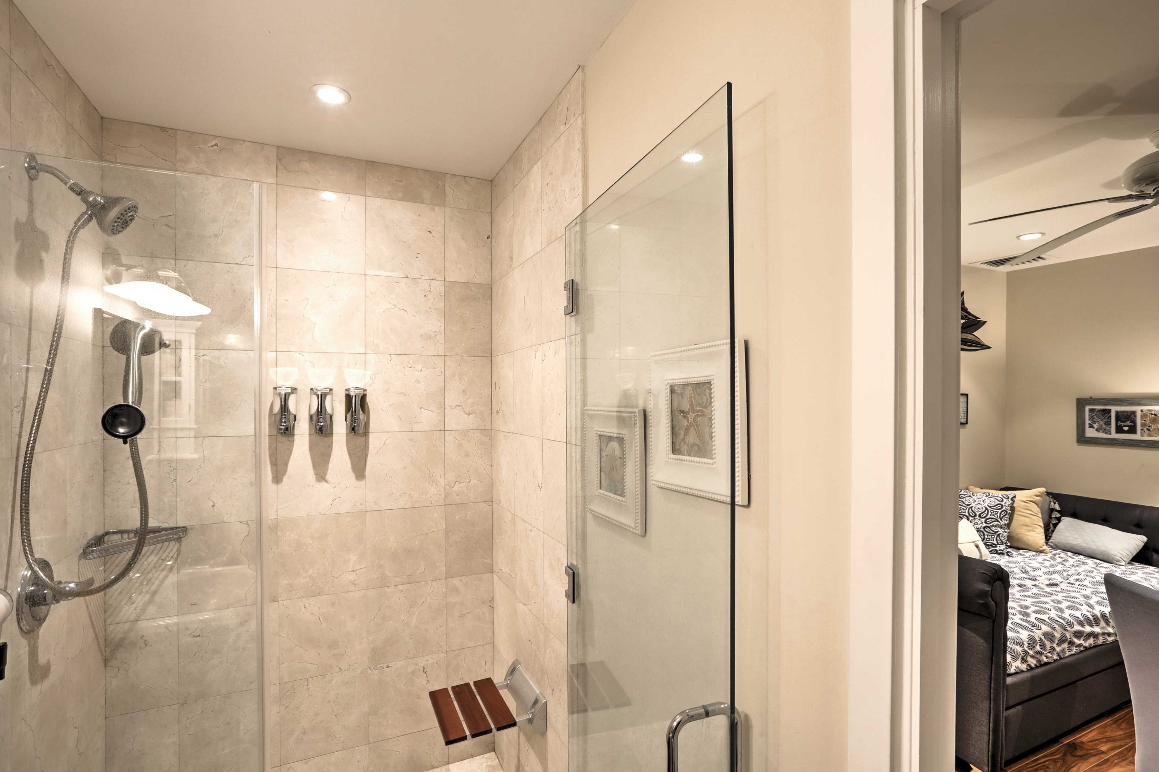The full bathroom has a walk-in shower, toiletries, bidet toilet, towels, and linens.