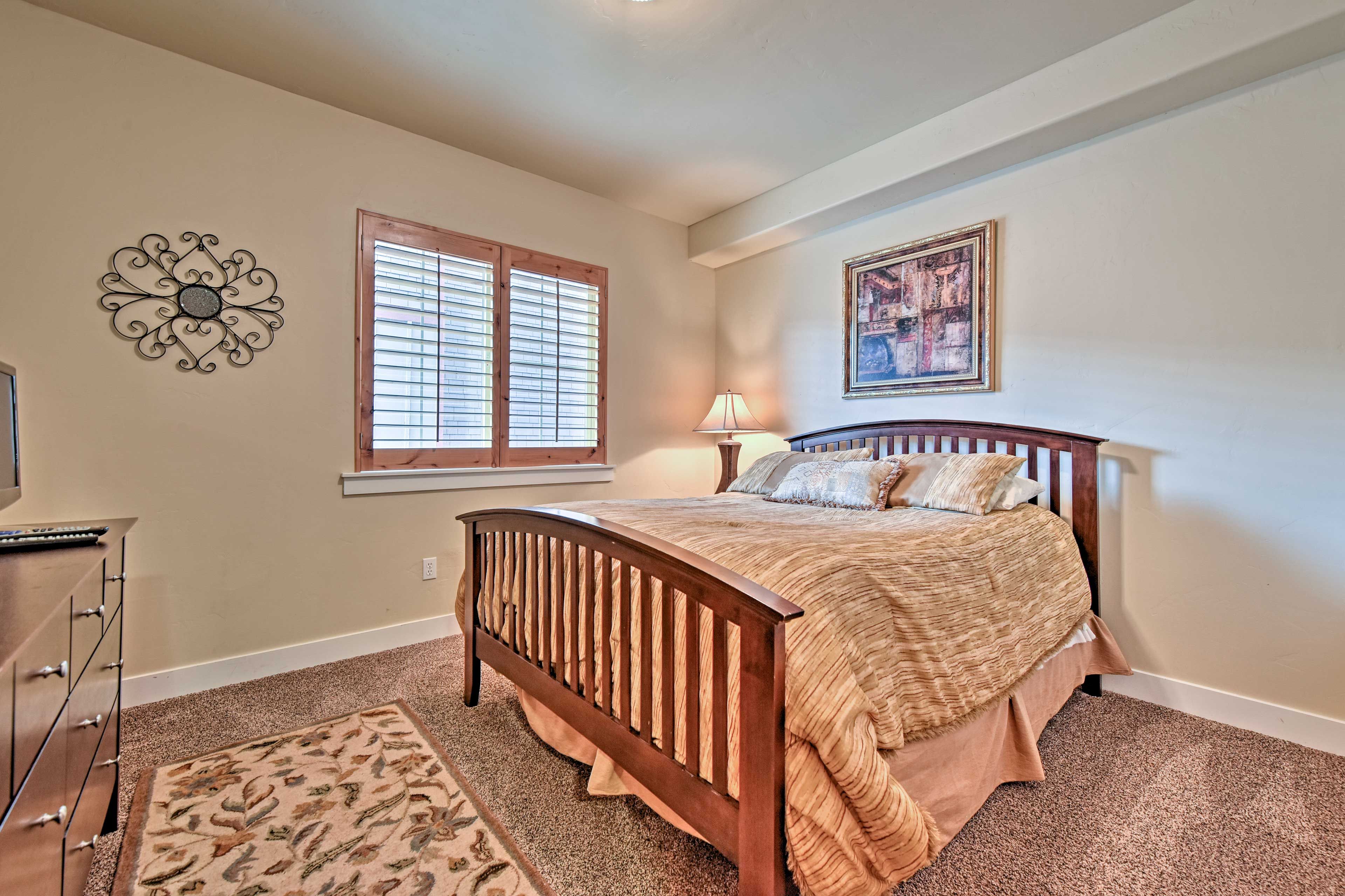This second bedroom features a queen-sized bed and flat-screen cable TV.