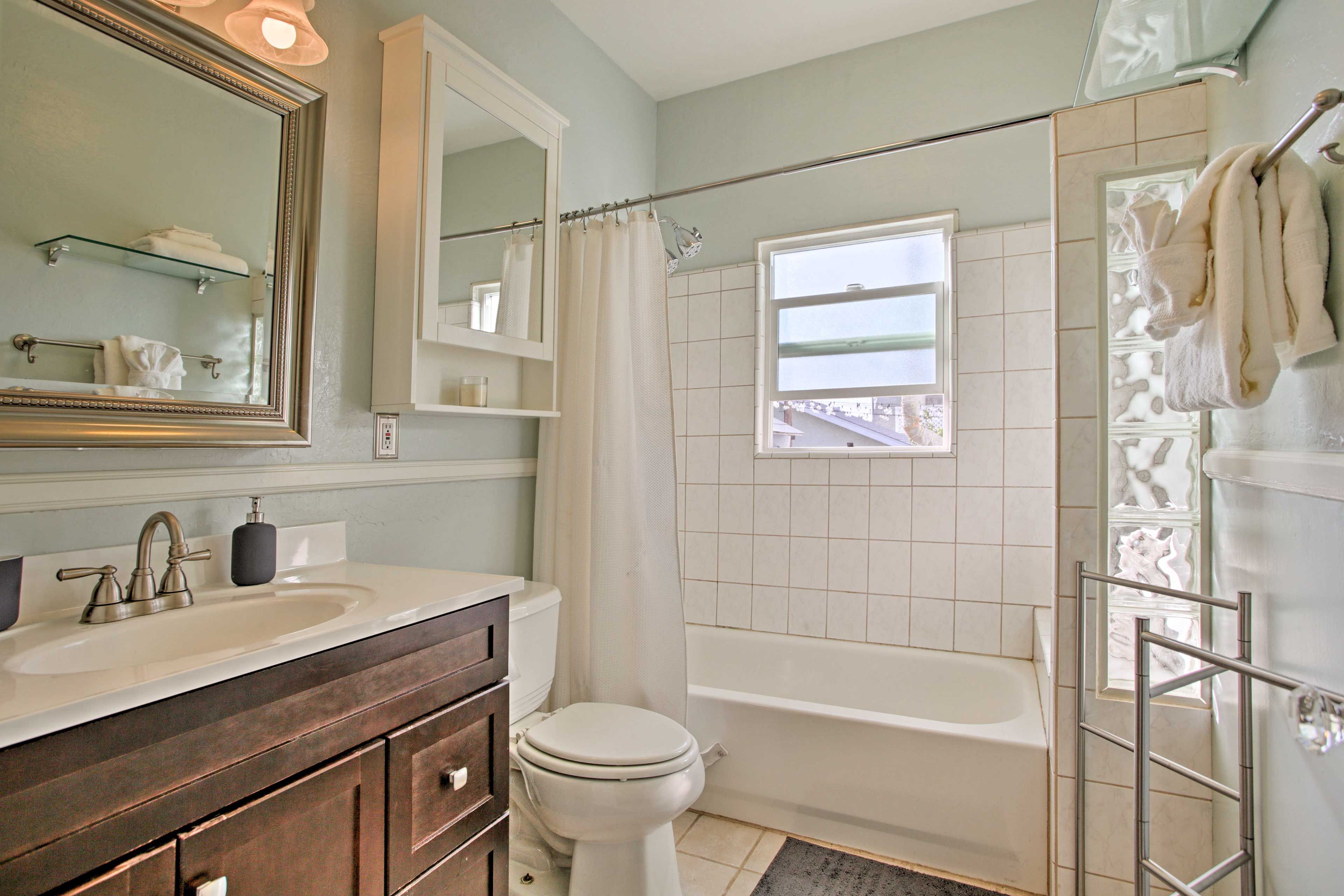 The second bathroom hosts a shower/tub combo and mirrored vanity.
