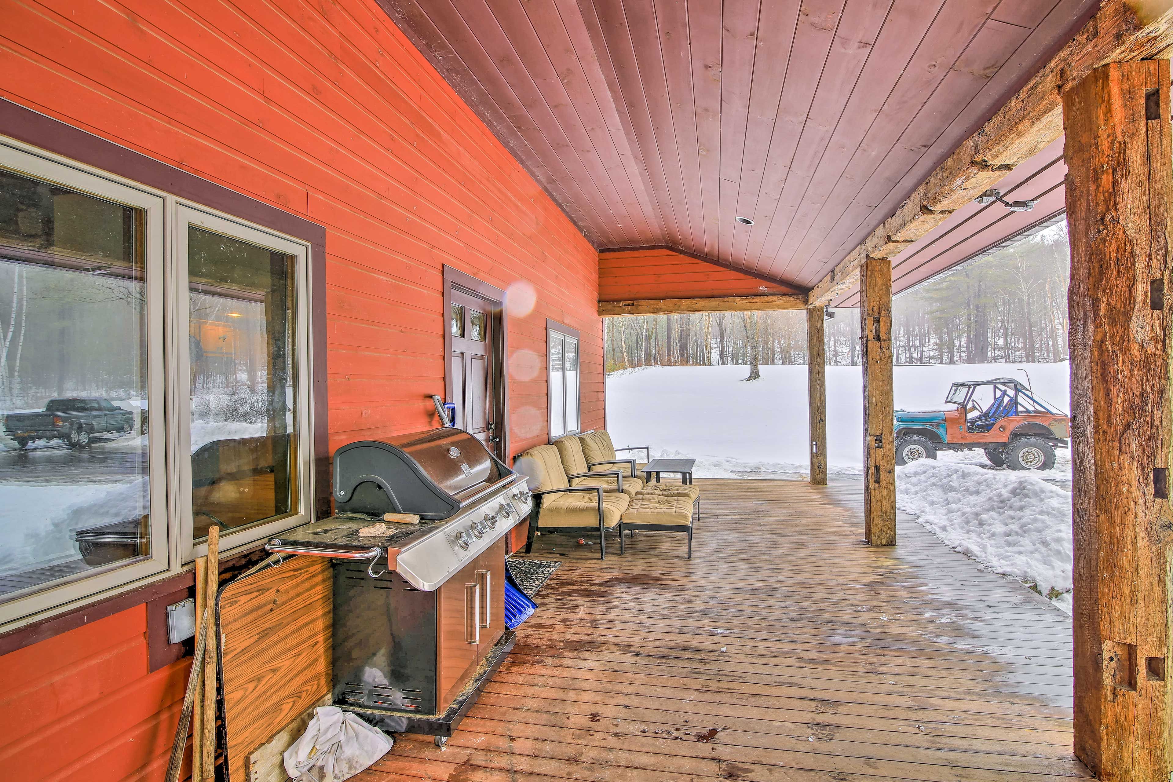 Lounge on the covered porch featuring patio furniture and a gas grill.