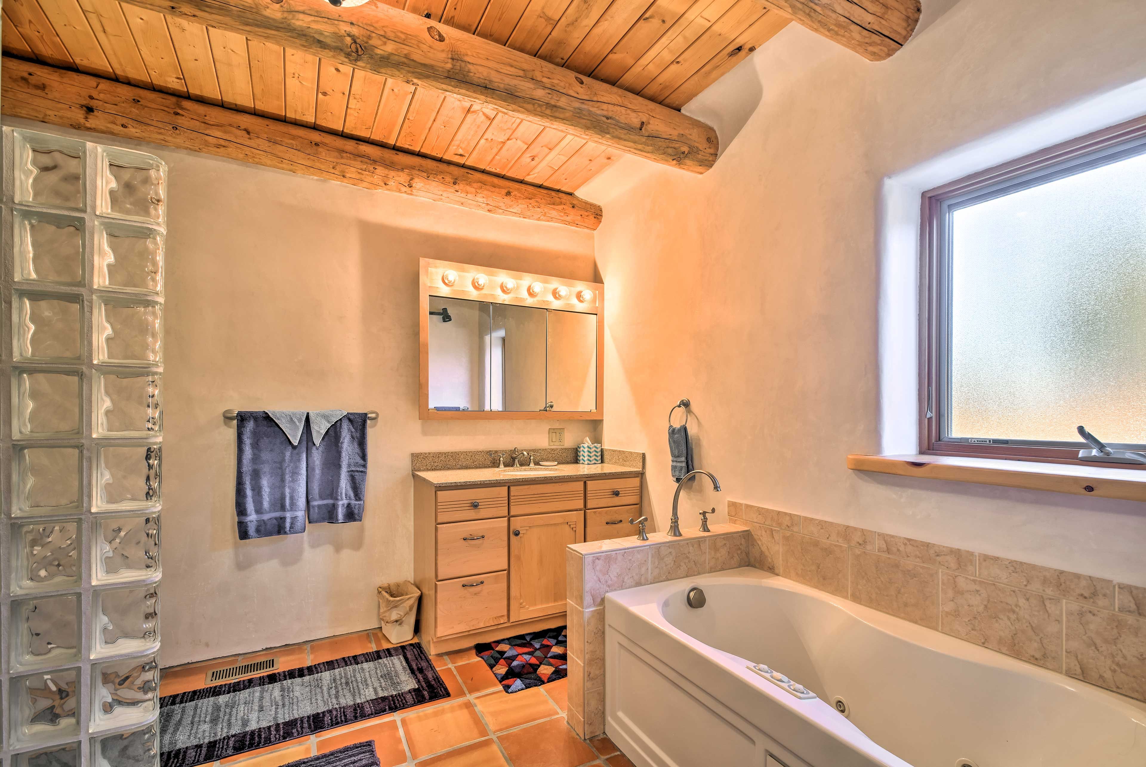 The en-suite bathroom provides a built-in tub and a walk-in shower.