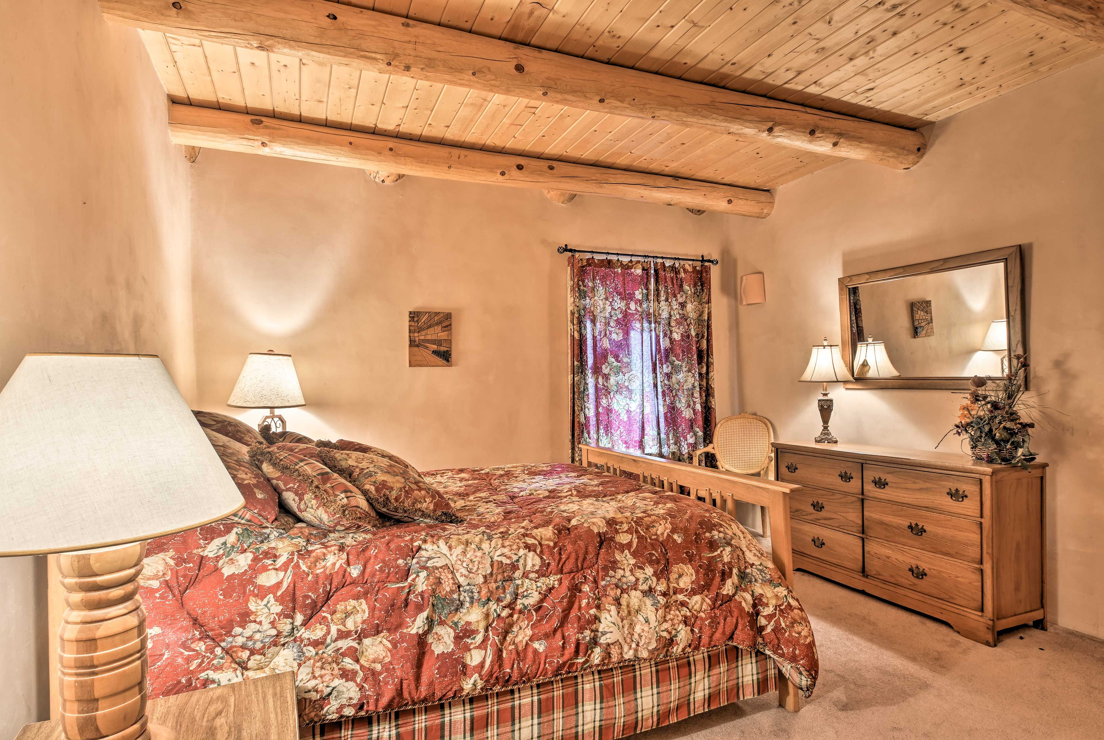 Exposed beams line the ceiling of this second bedroom equipped with a queen bed.