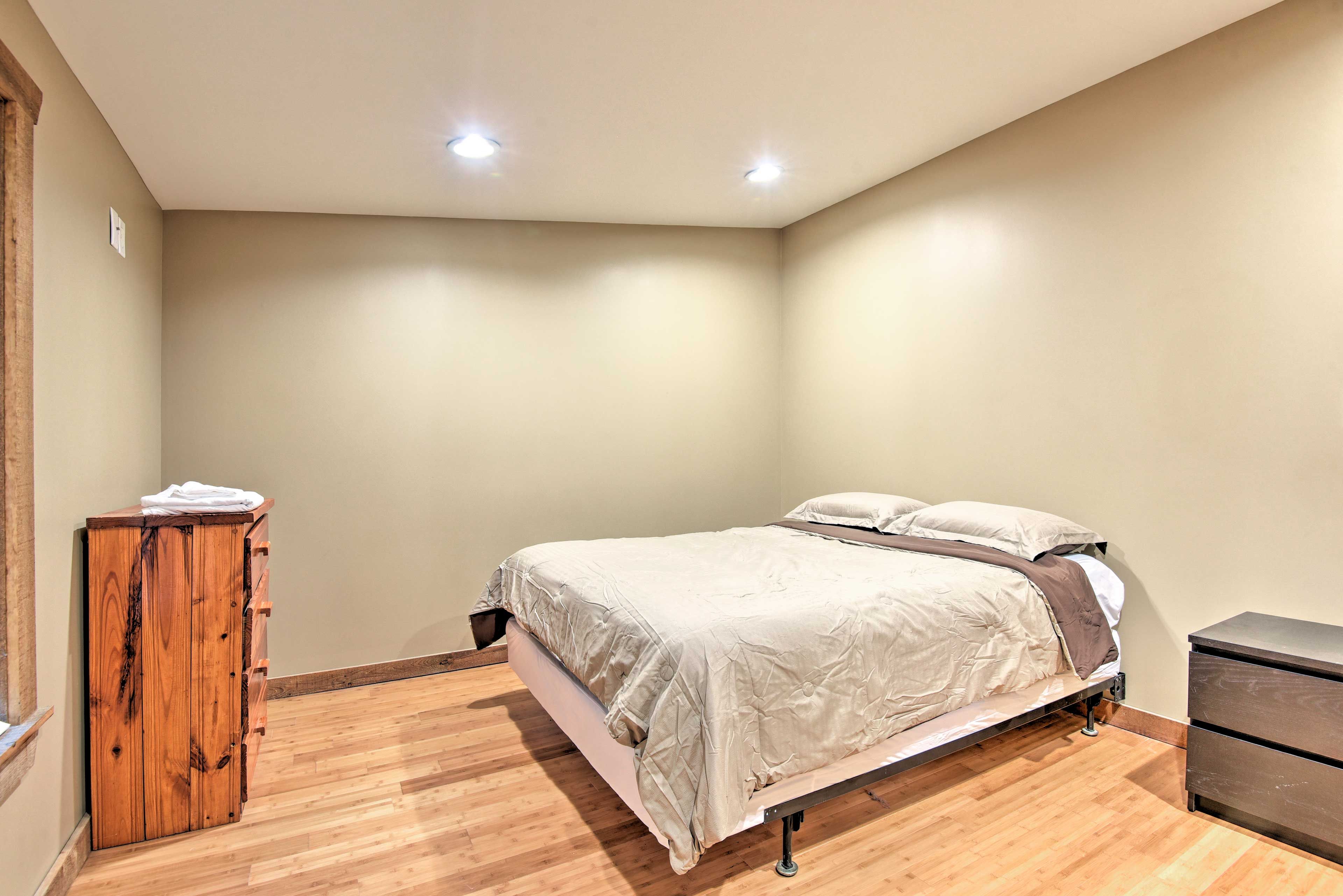 This bedroom is complete with a queen bed.