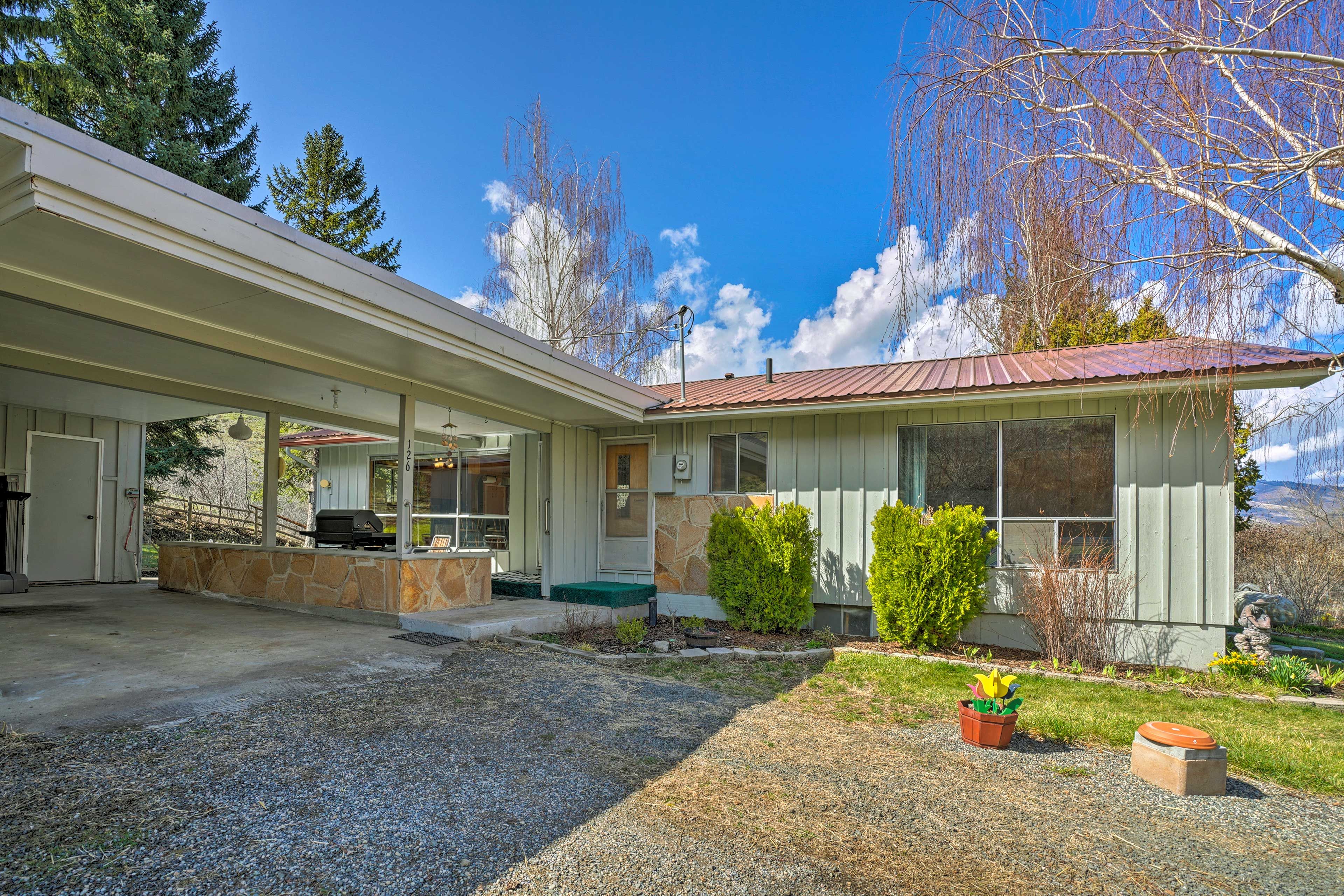 This charming ranch-style home has a garden and lush green lawn.