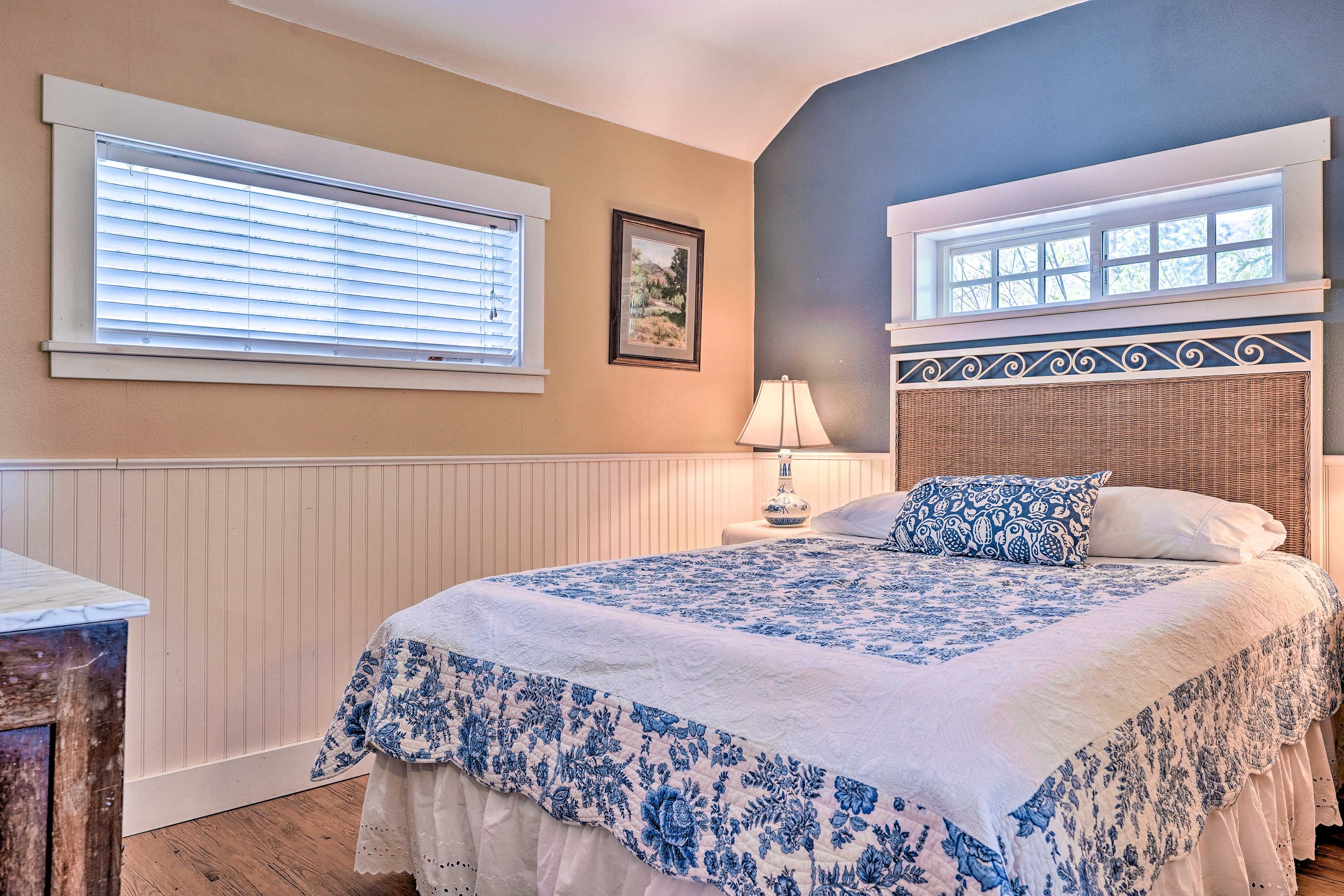 The queen-sized bed is framed by high windows, offering privacy and light.