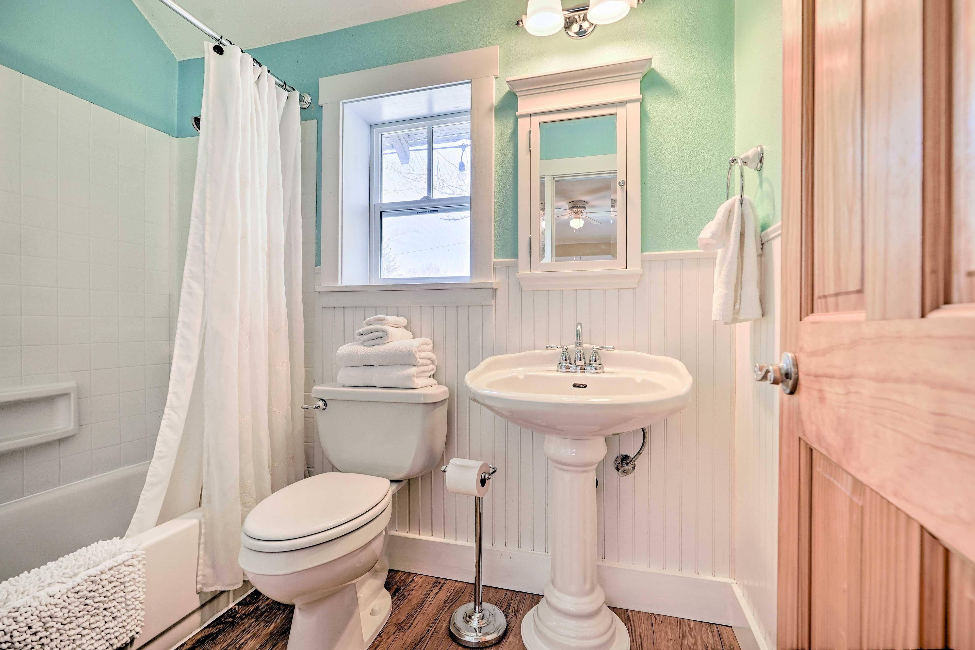 This charming mint-green ensuite bathroom has a shower/tub combo.