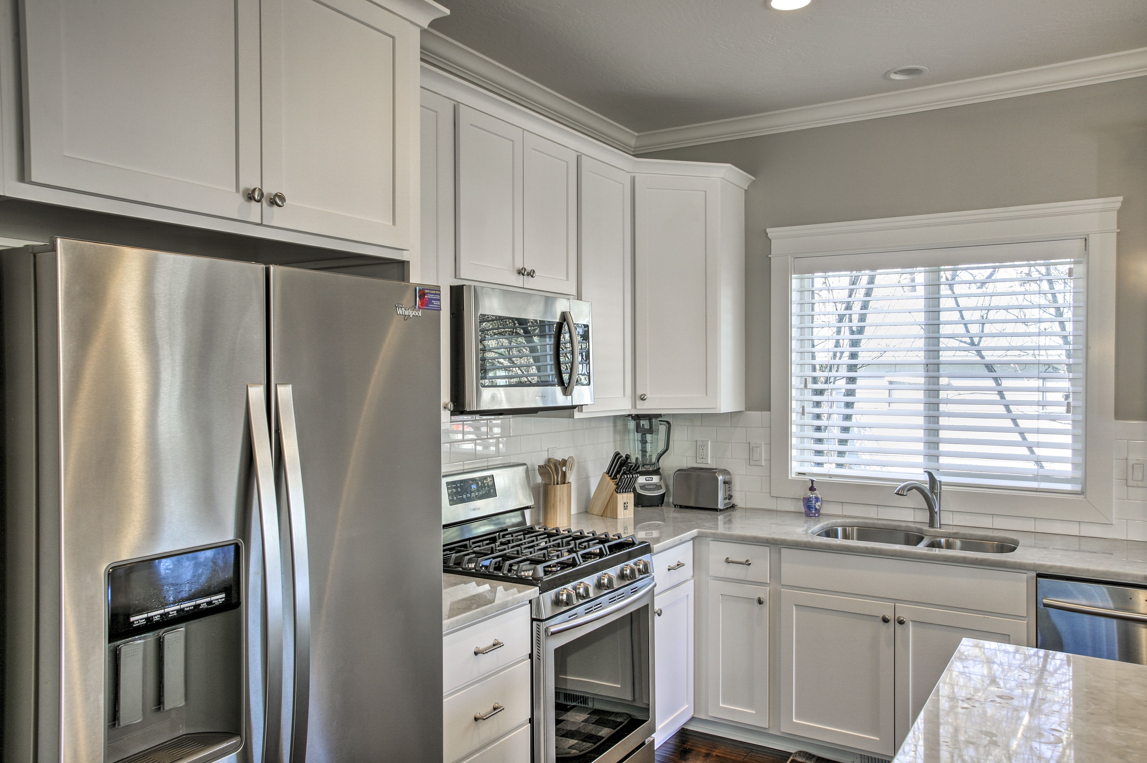 Stainless steel appliances gleam against white cabinets.