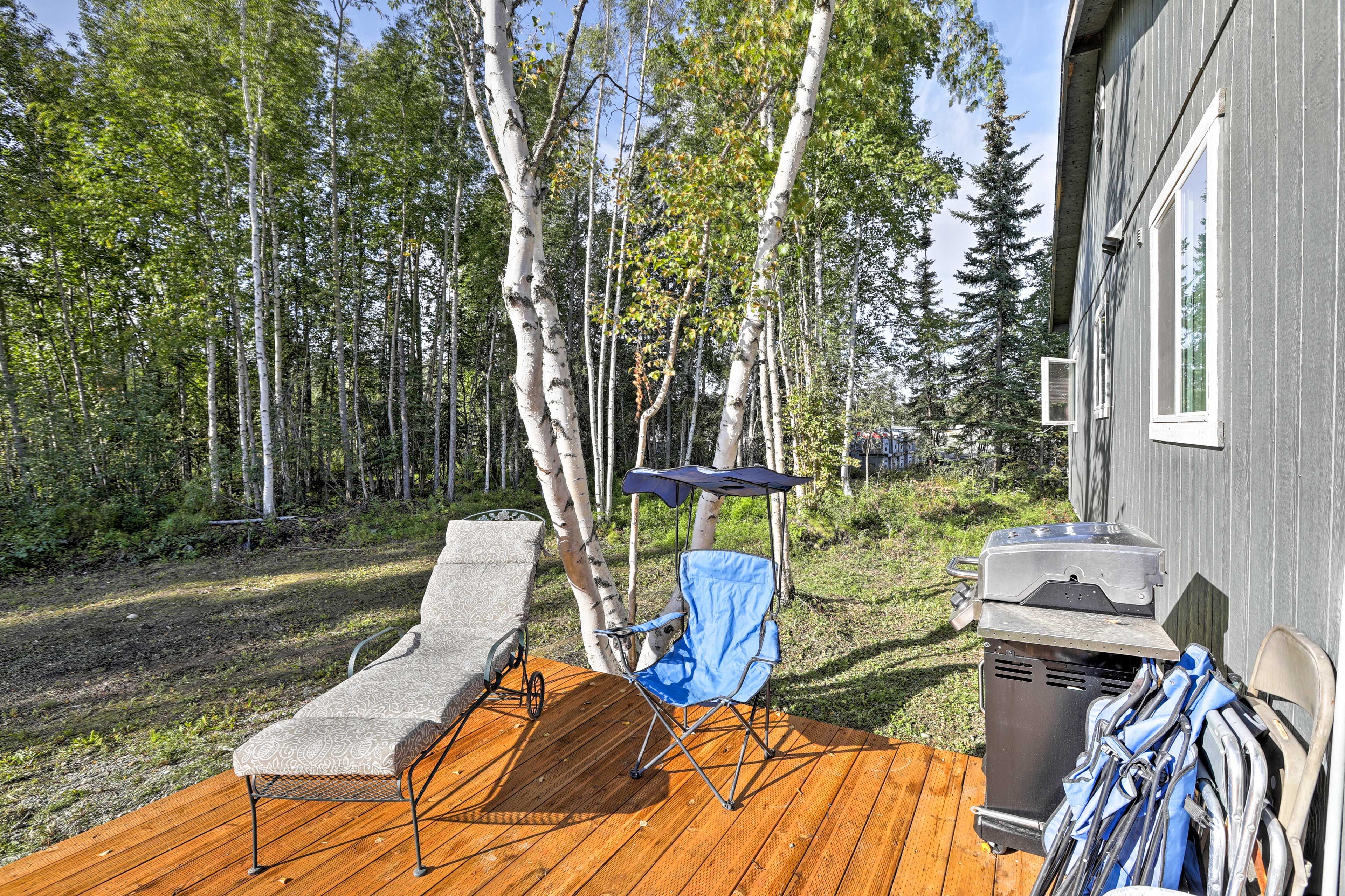 The apartment is surrounded by towering trees.