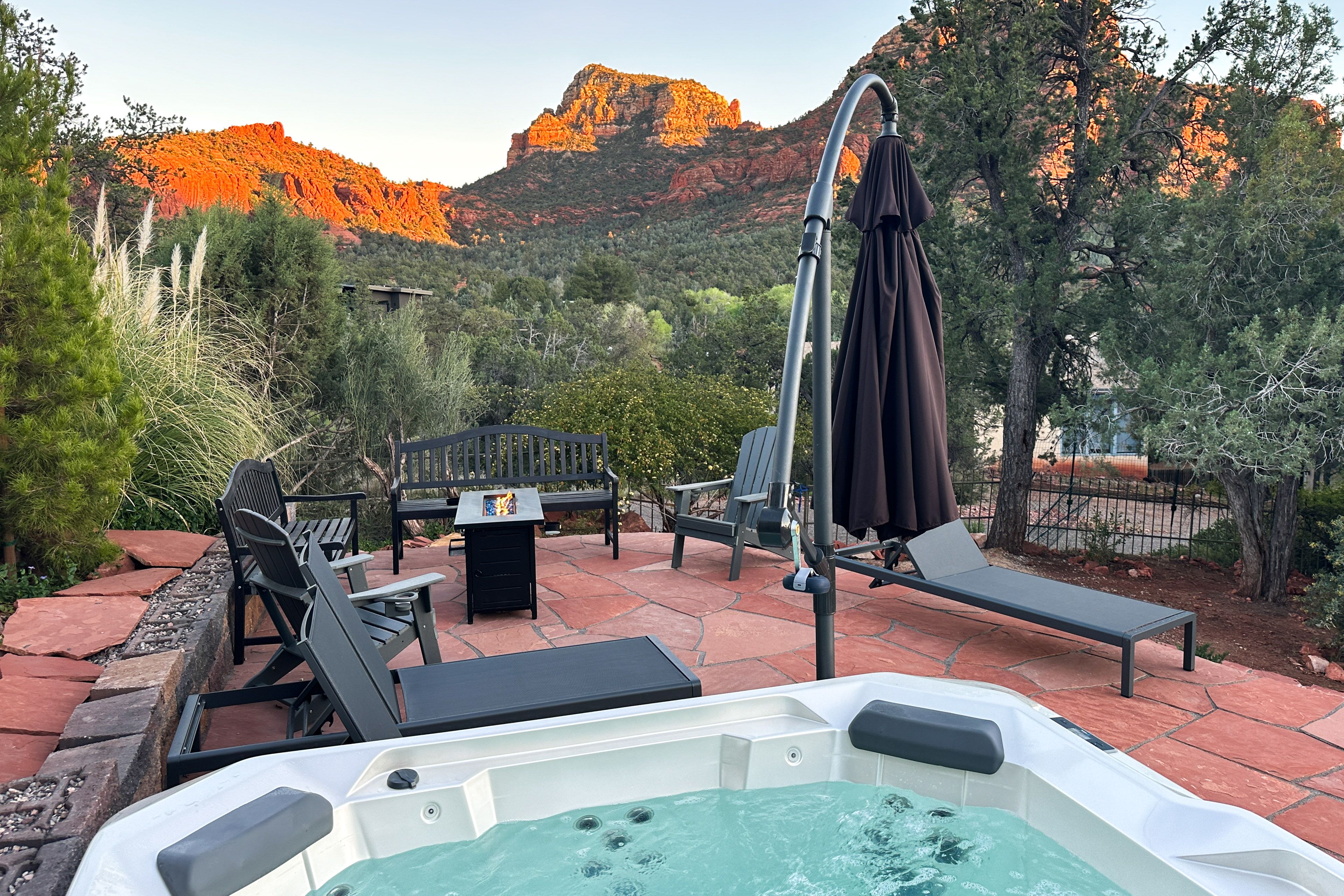 Private hot tub open, fire pit lit, red rock canyon glowing at sunset