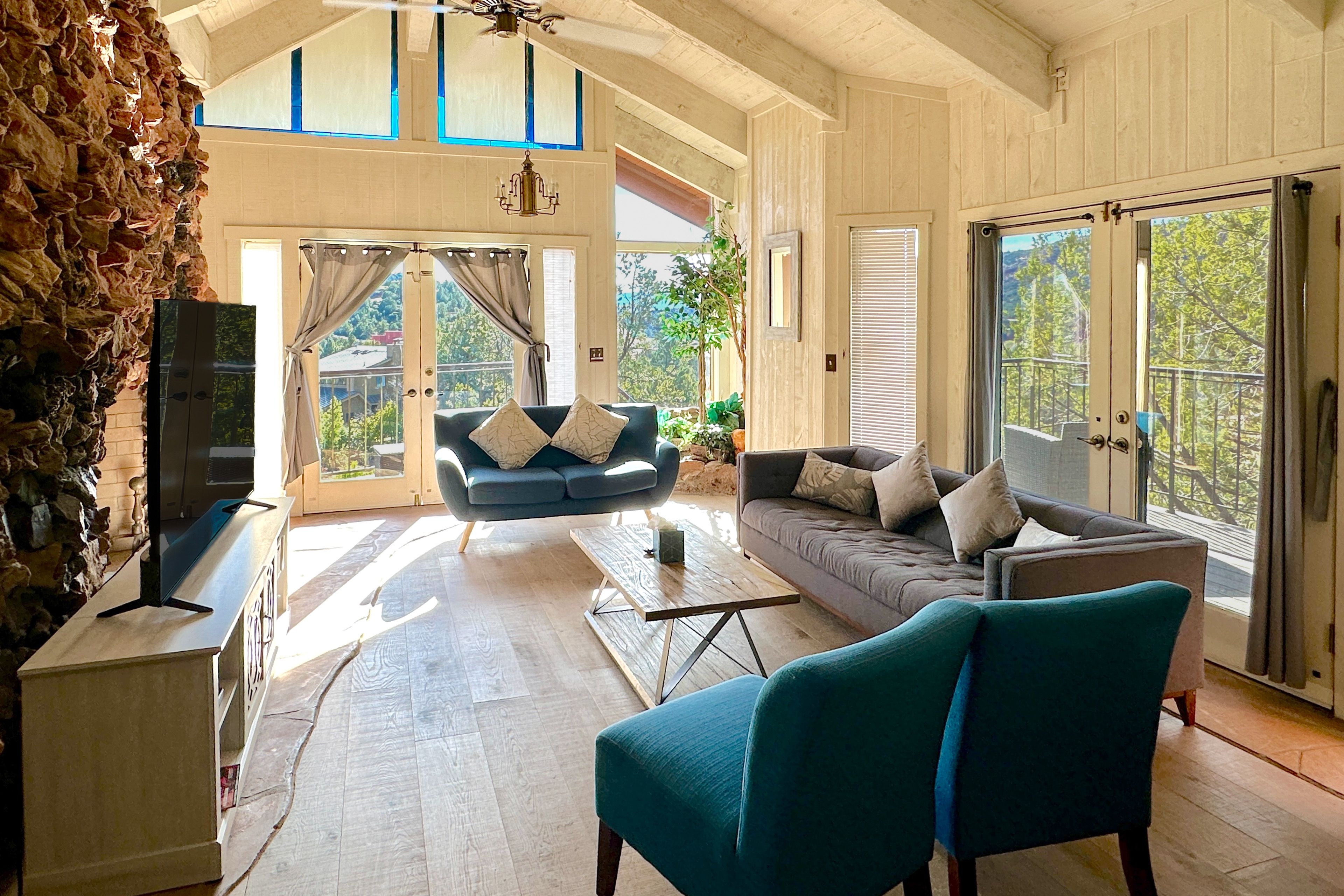 Main living room, soaring vaulted ceilings, handcrafted stone wall, French doors