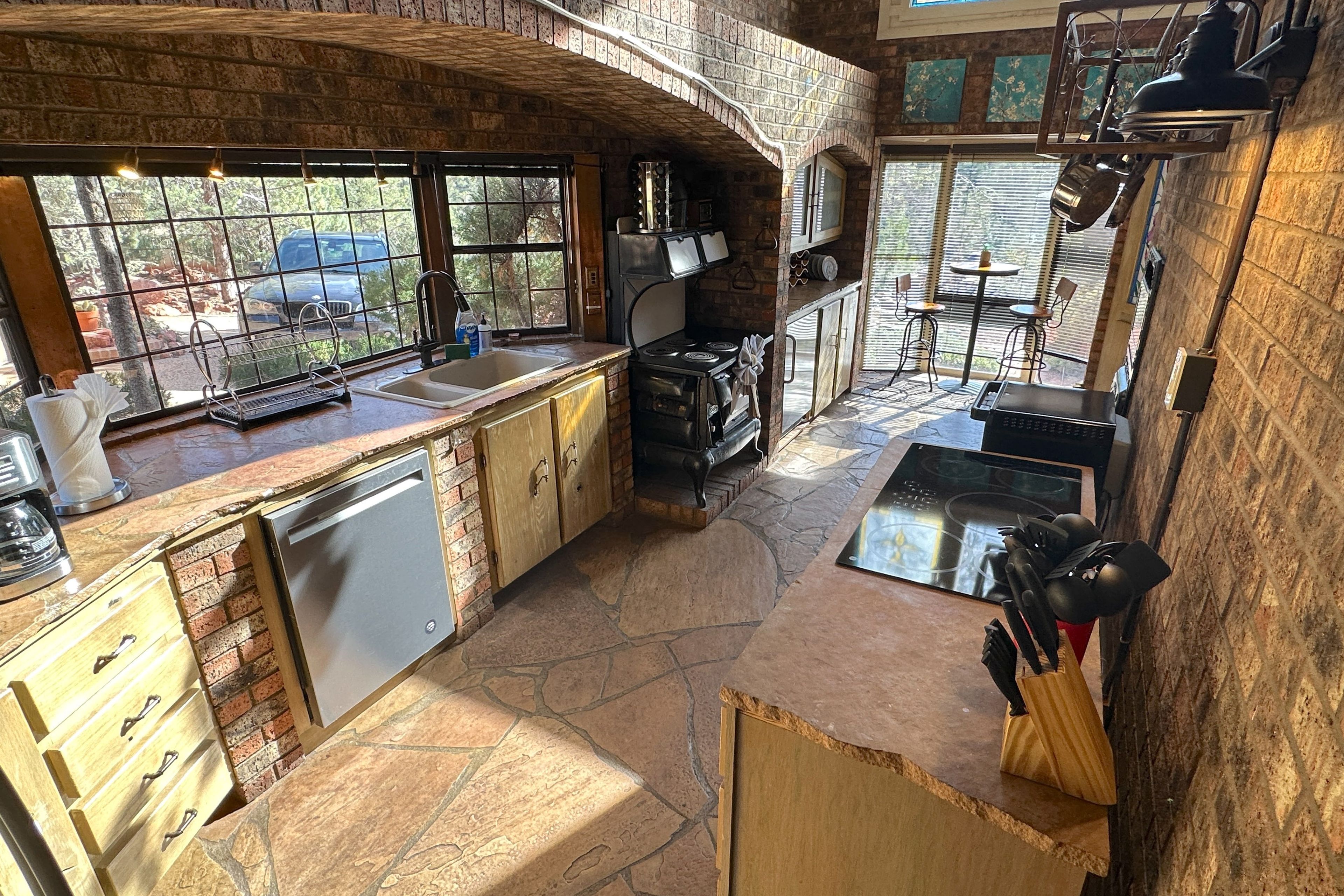Stone-arched kitchen with vintage iron oven and induction cooktop