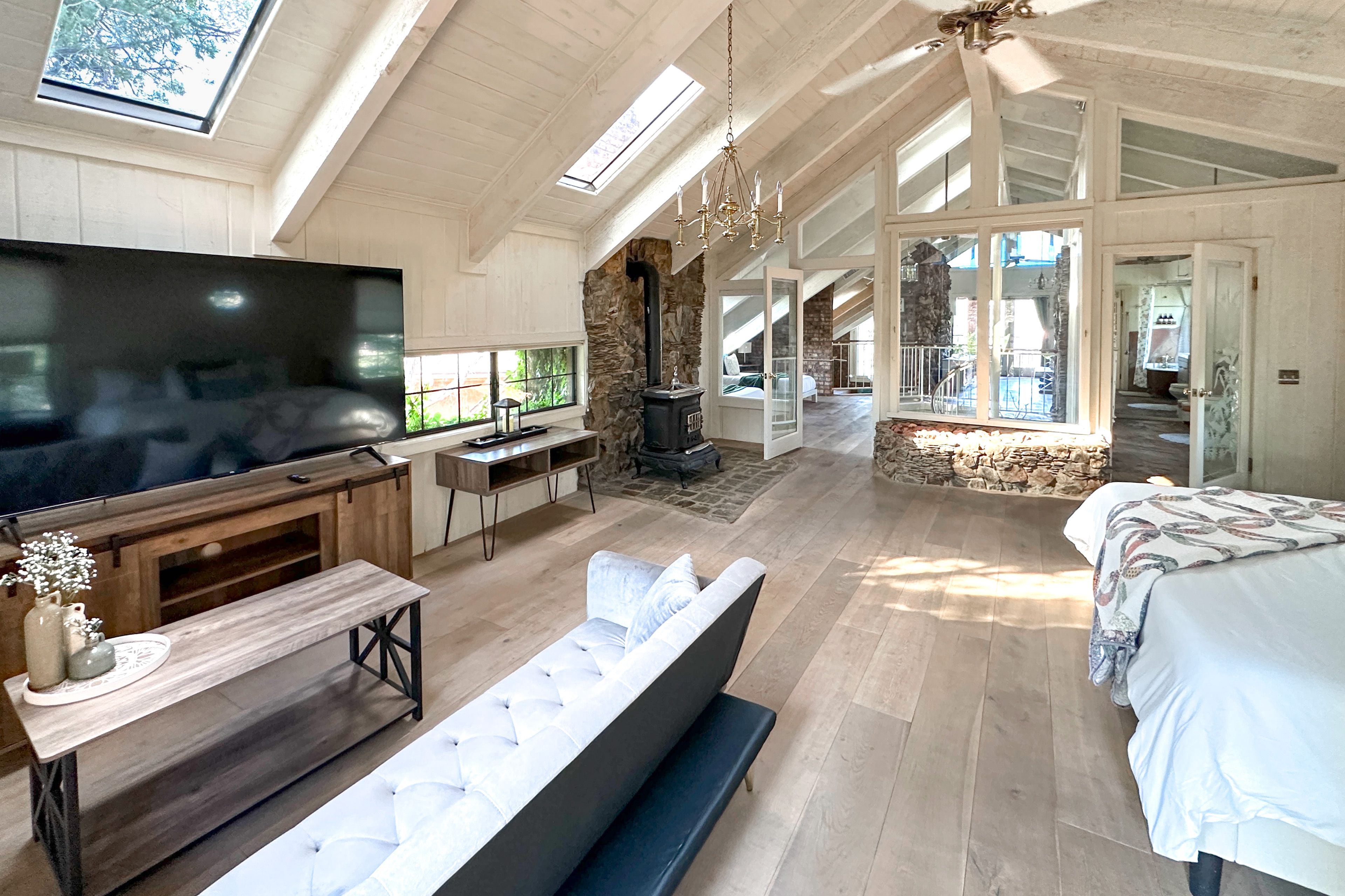 Bedroom suite is a full floor — skylights, cast iron stove, seating, king bed