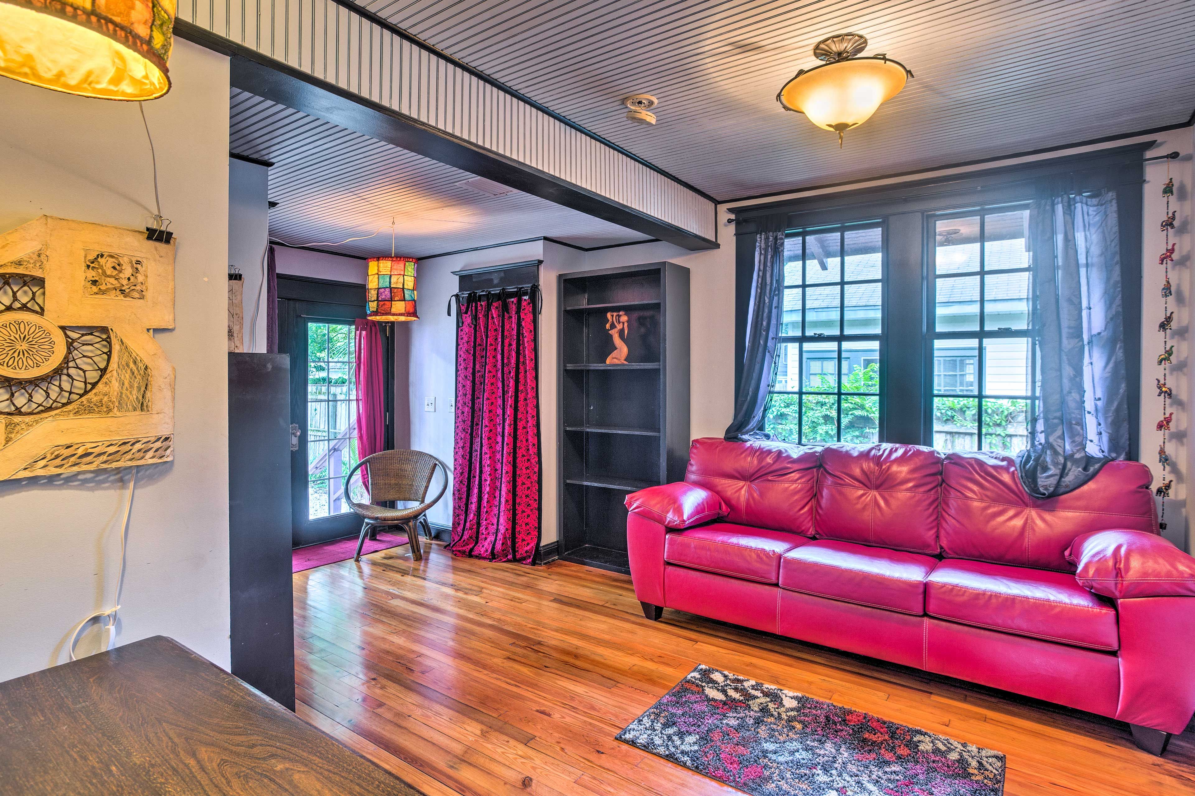 A third living space features a plush pink sofa.
