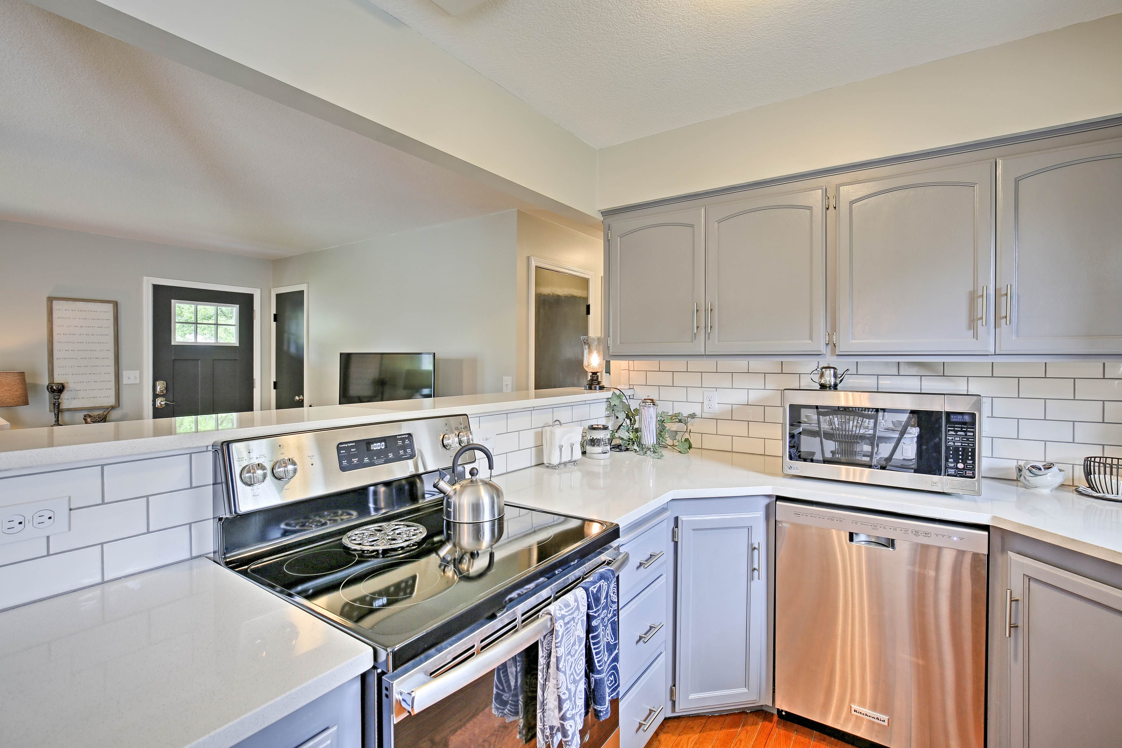 Stainless steel appliances shine against the grey cabinets and granite counters.