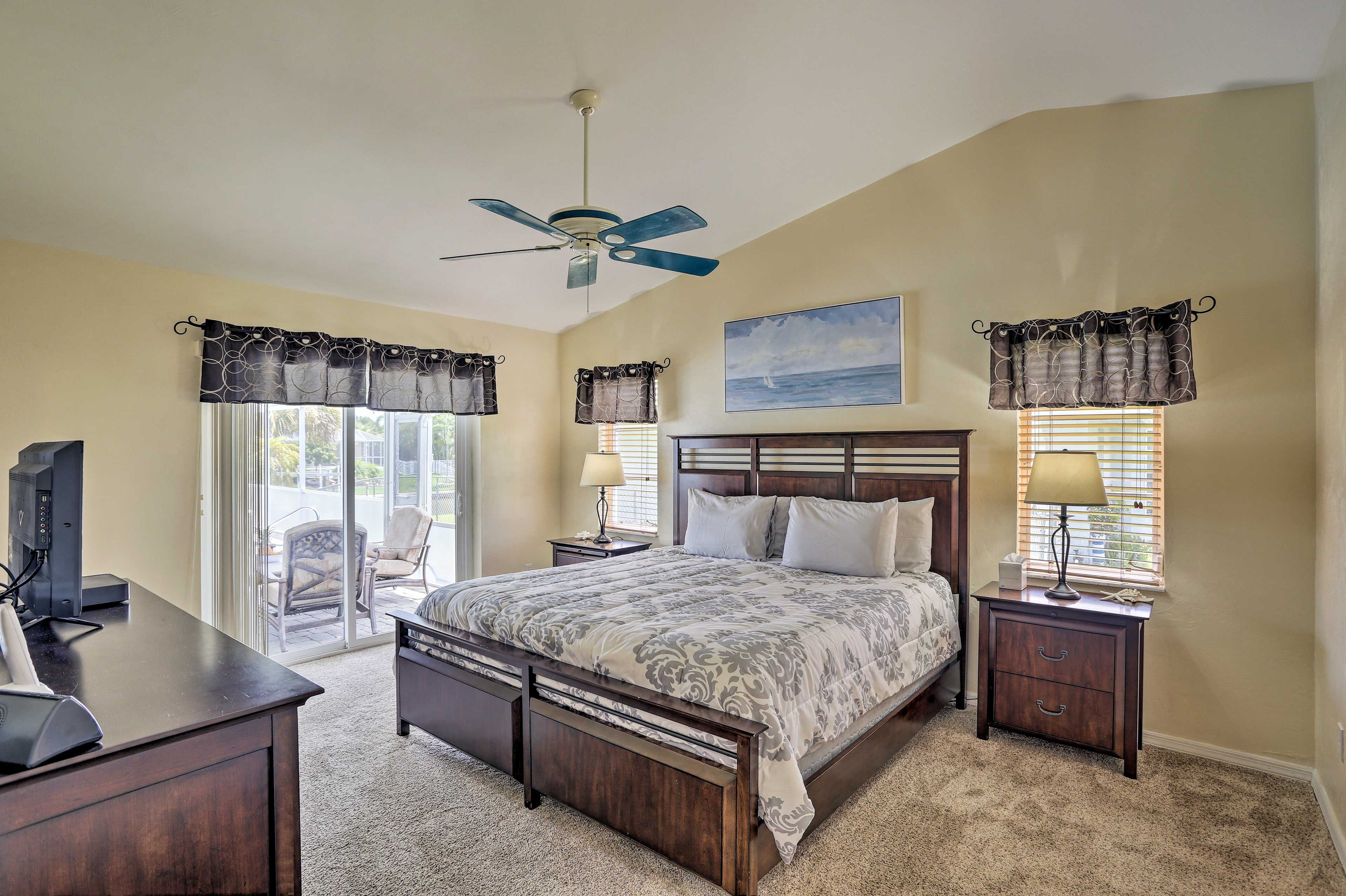 The primary bedroom offers direct access to the lanai, spa, and pool.