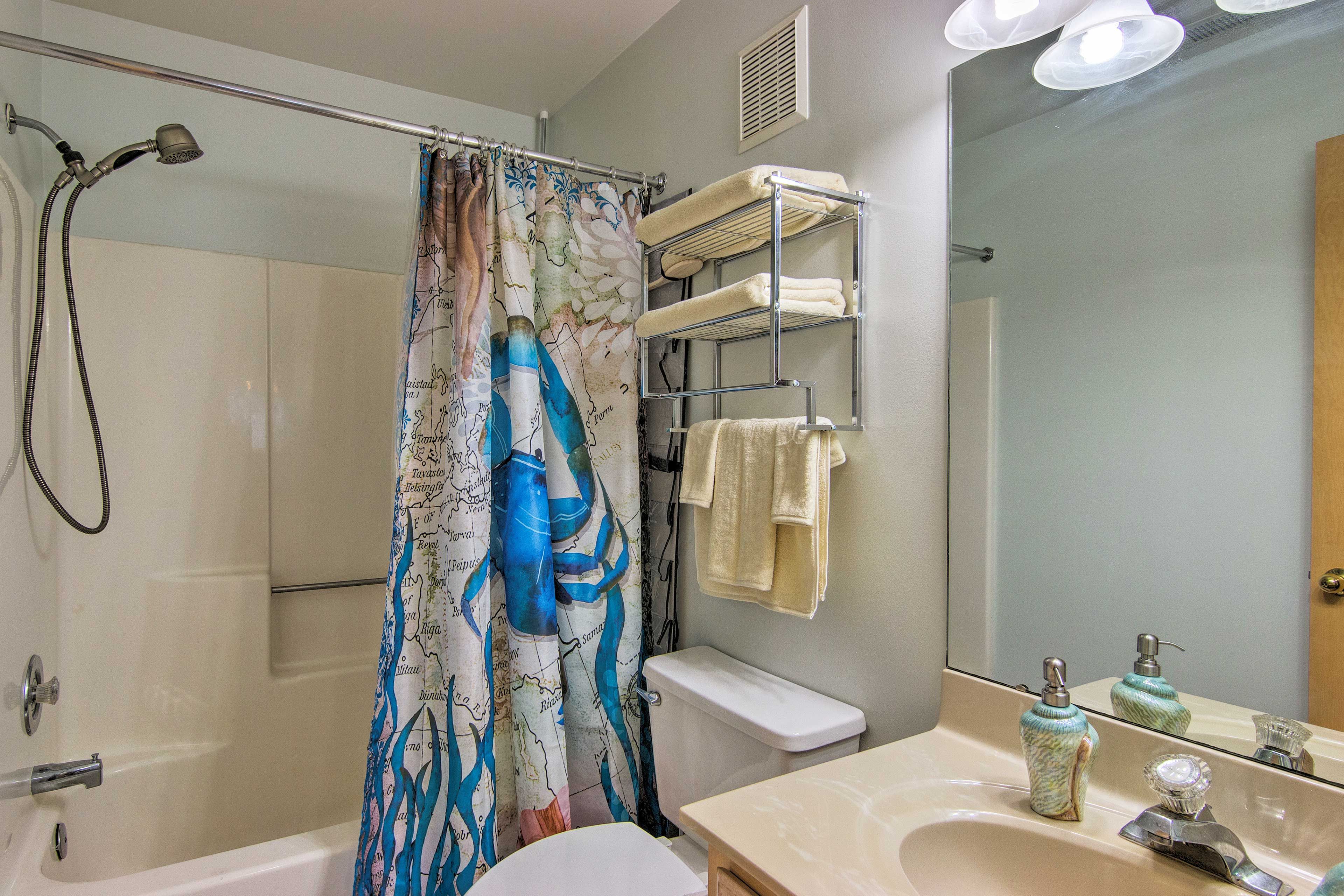 A full bathroom hosts nautical decor and a shower/tub combo.