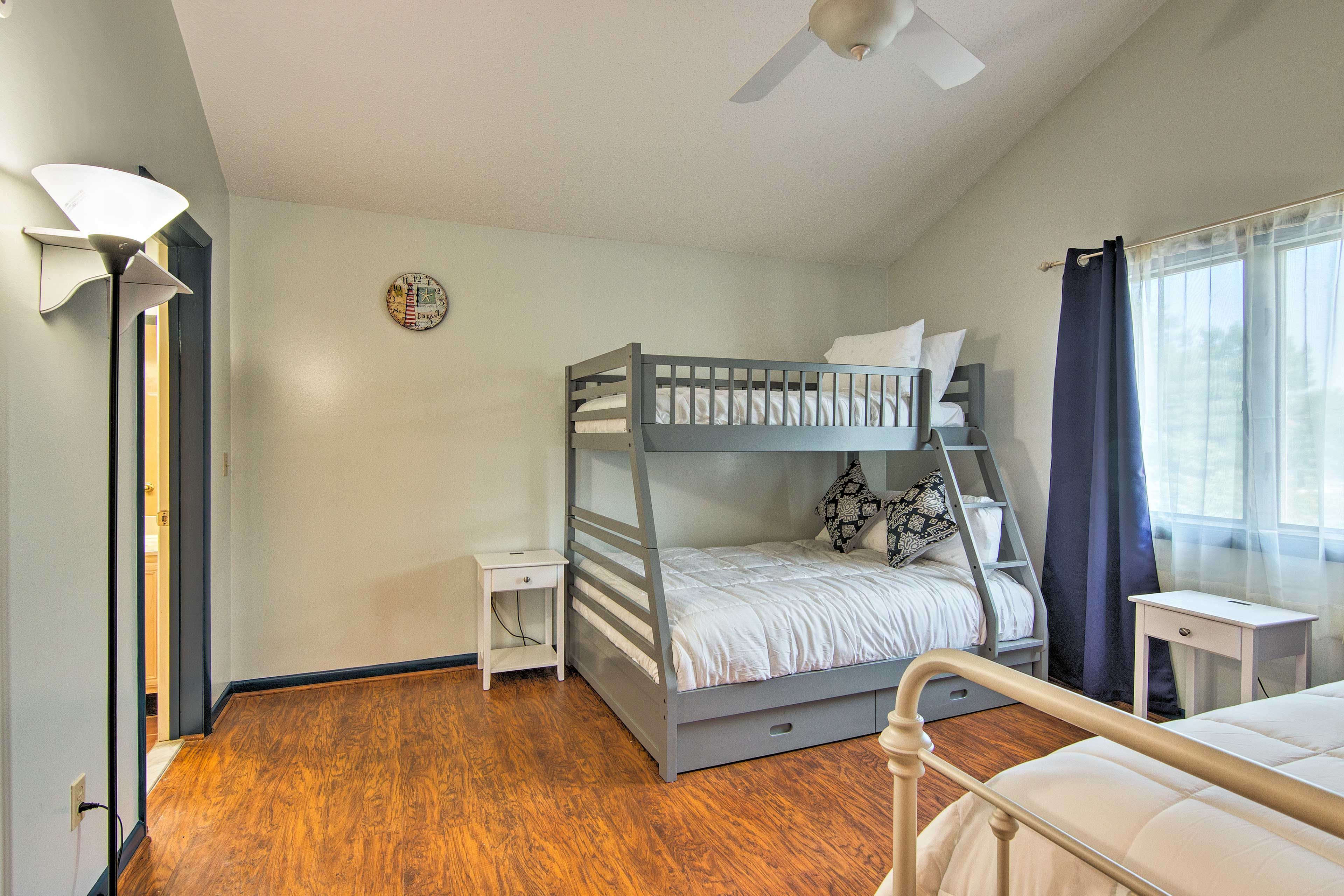 Picture windows open to let sunlight in and illuminate the hardwood floor.