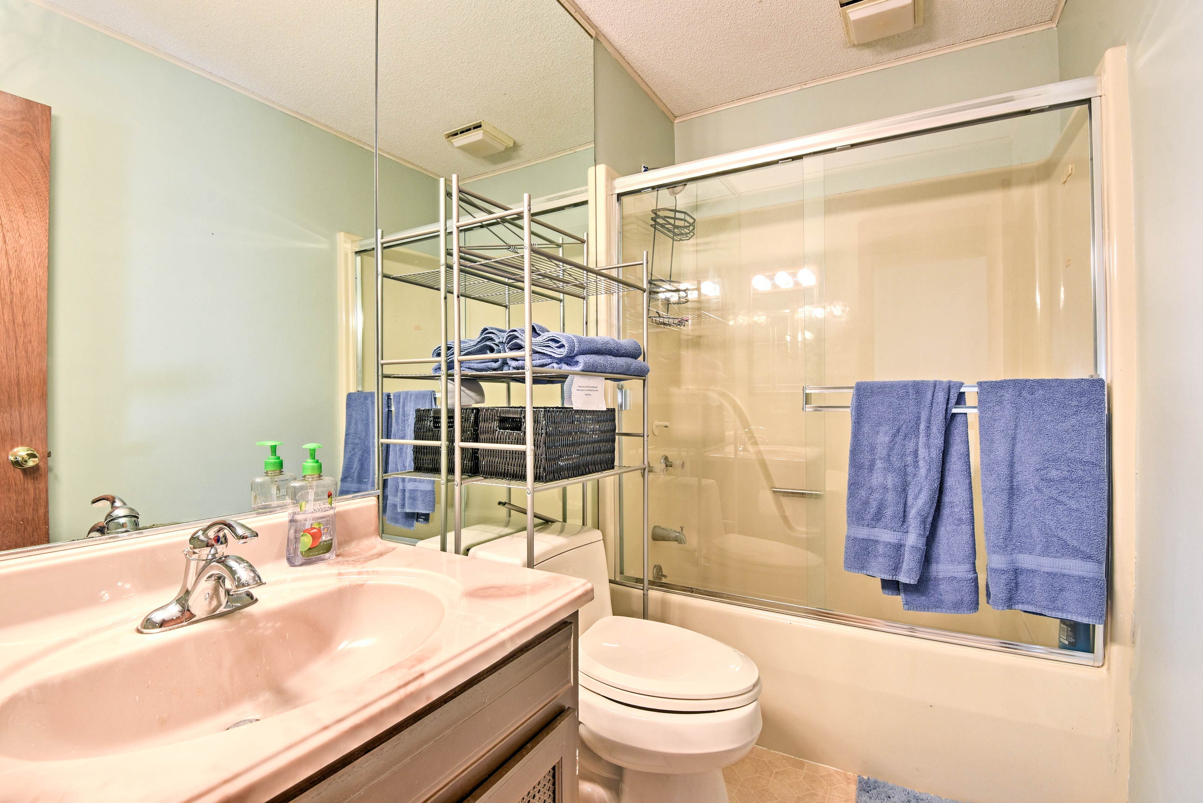Sliding glass doors line the shower/tub combo in this full bathroom.