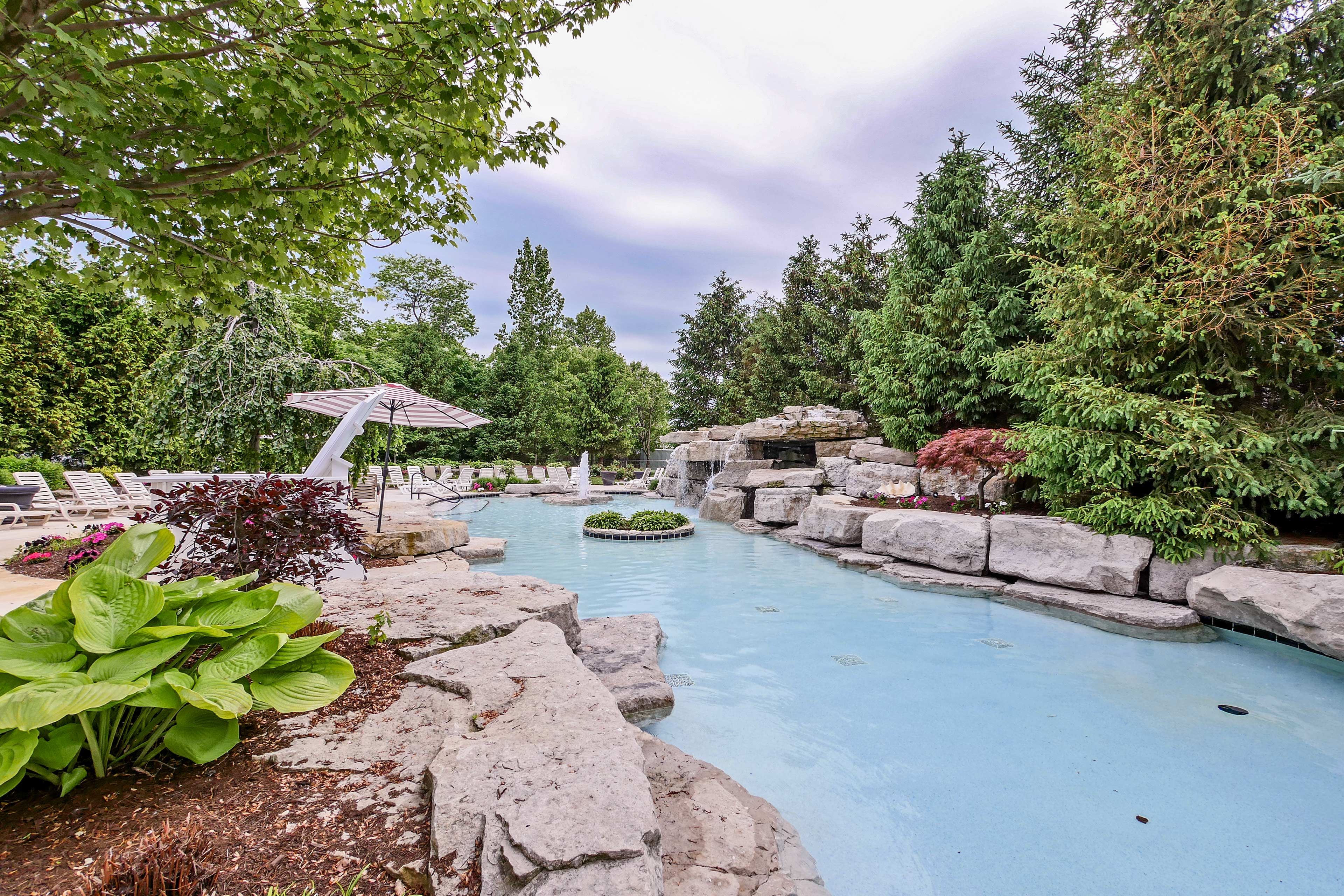 The pool is surrounded by landscaping and seating.