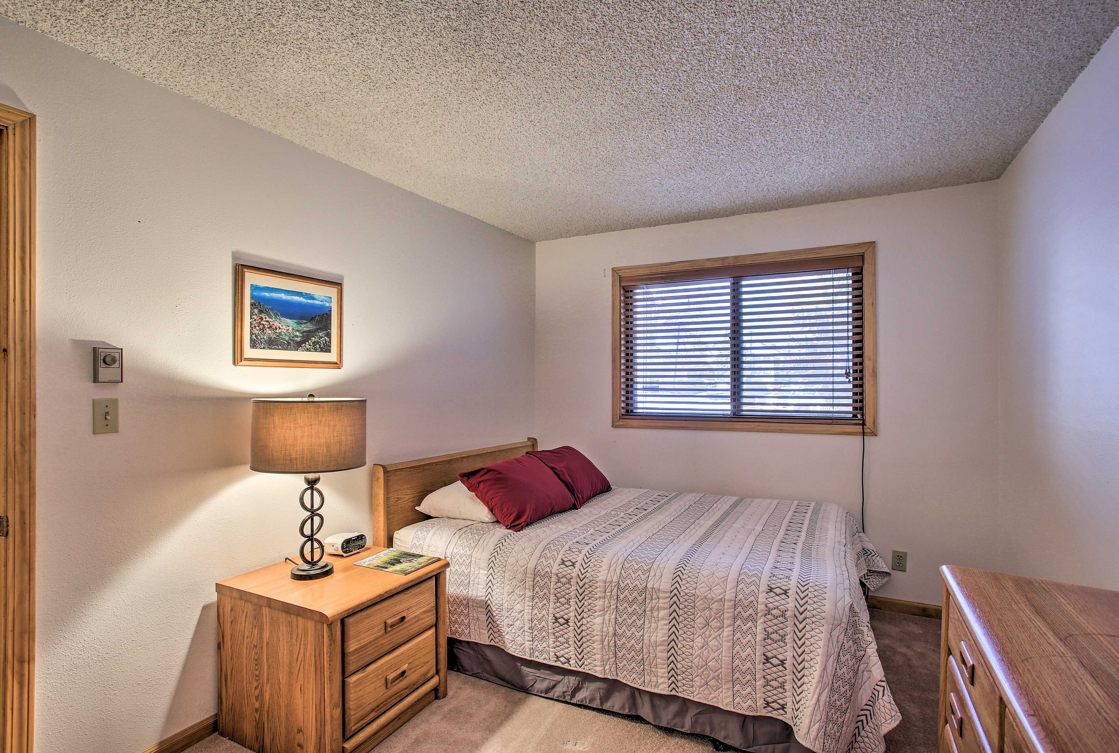The first bedroom boasts a comfortable queen bed.