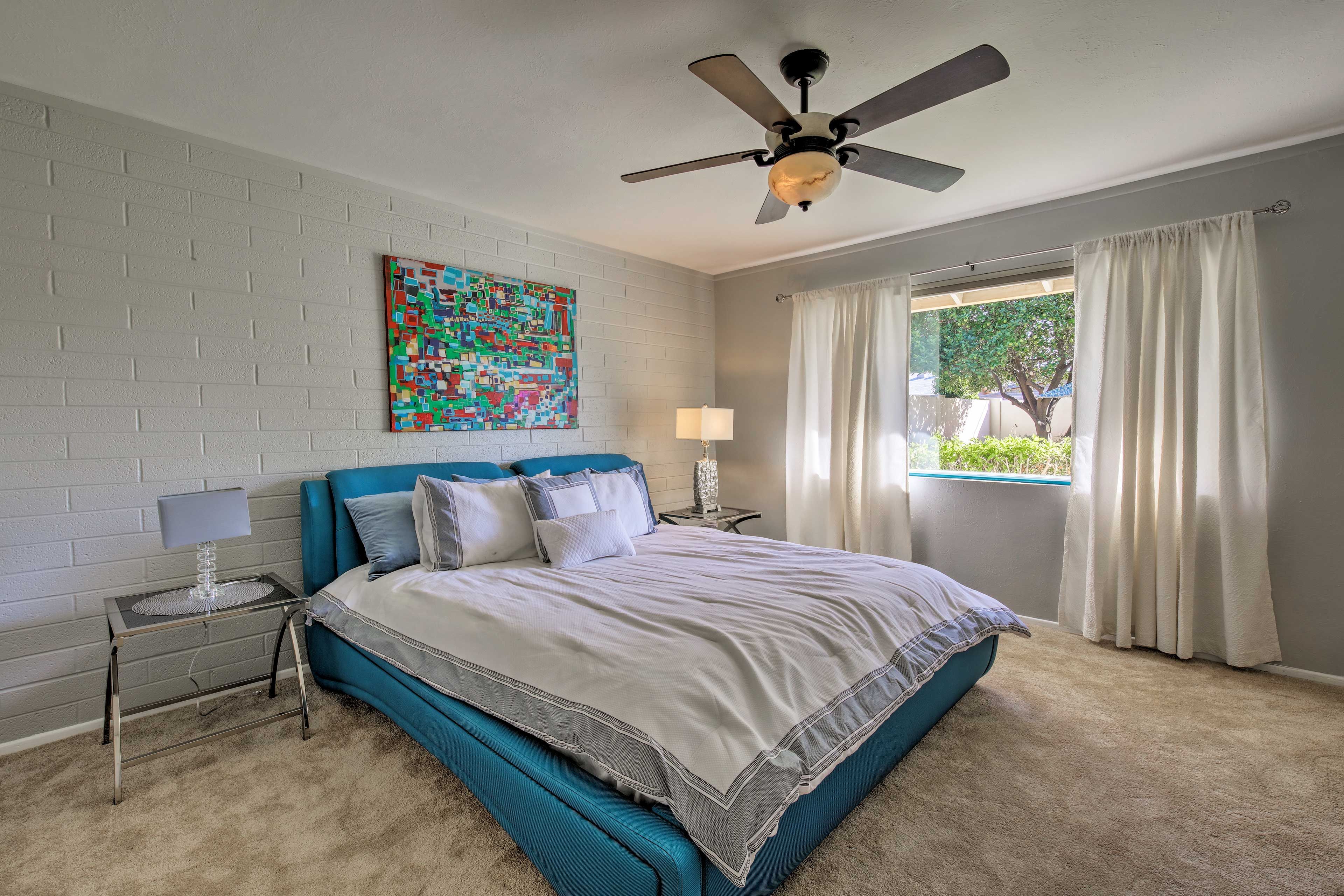 This bedroom boasts a king bed and large window.