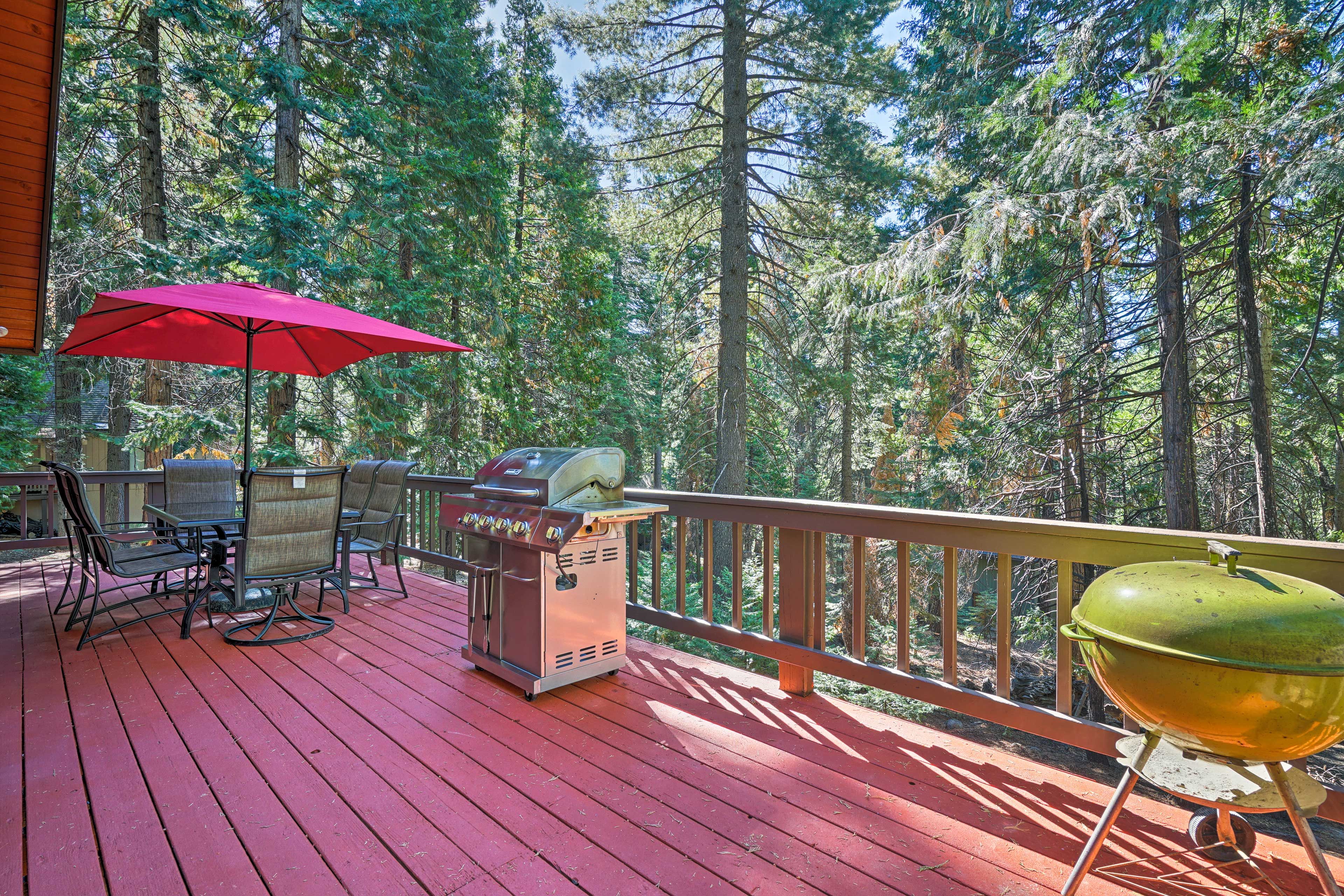 The secluded home boasts a wraparound deck with views of surrounding trees.
