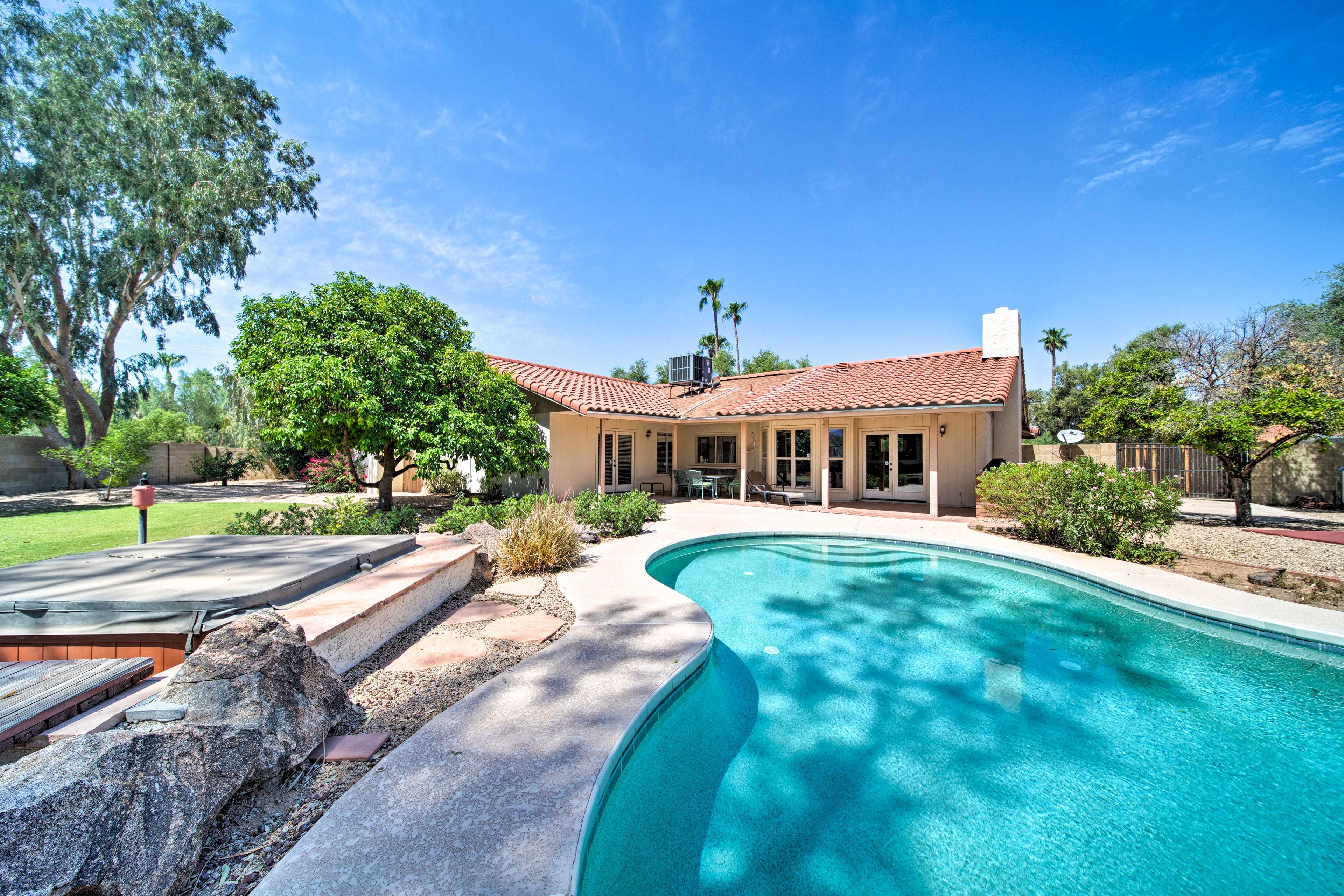 The gorgeous outdoor space features a private pool, hot tub, and tennis court!
