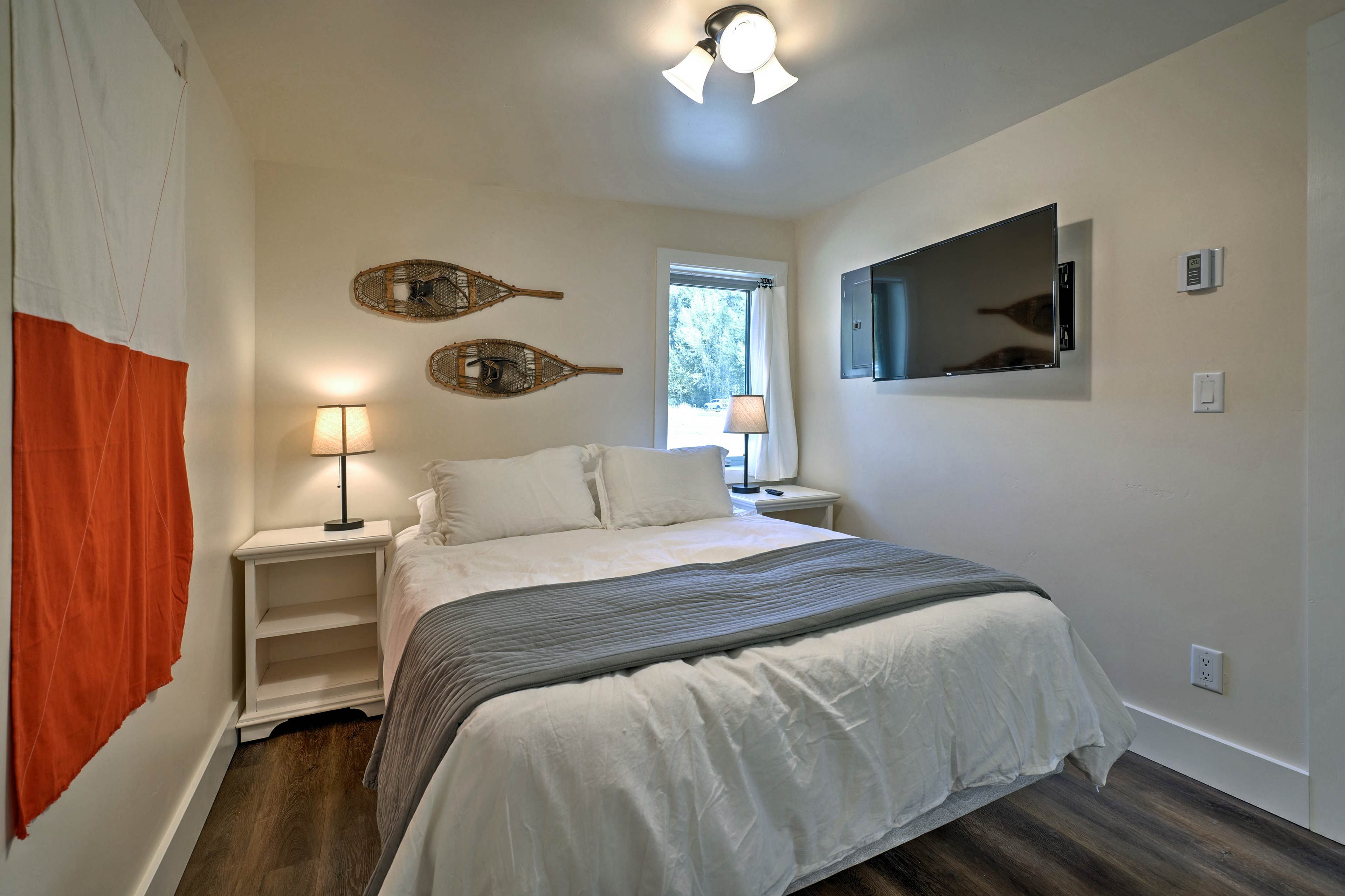 The downstairs bedroom boasts a cloud-like queen bed and flat-screen TV.