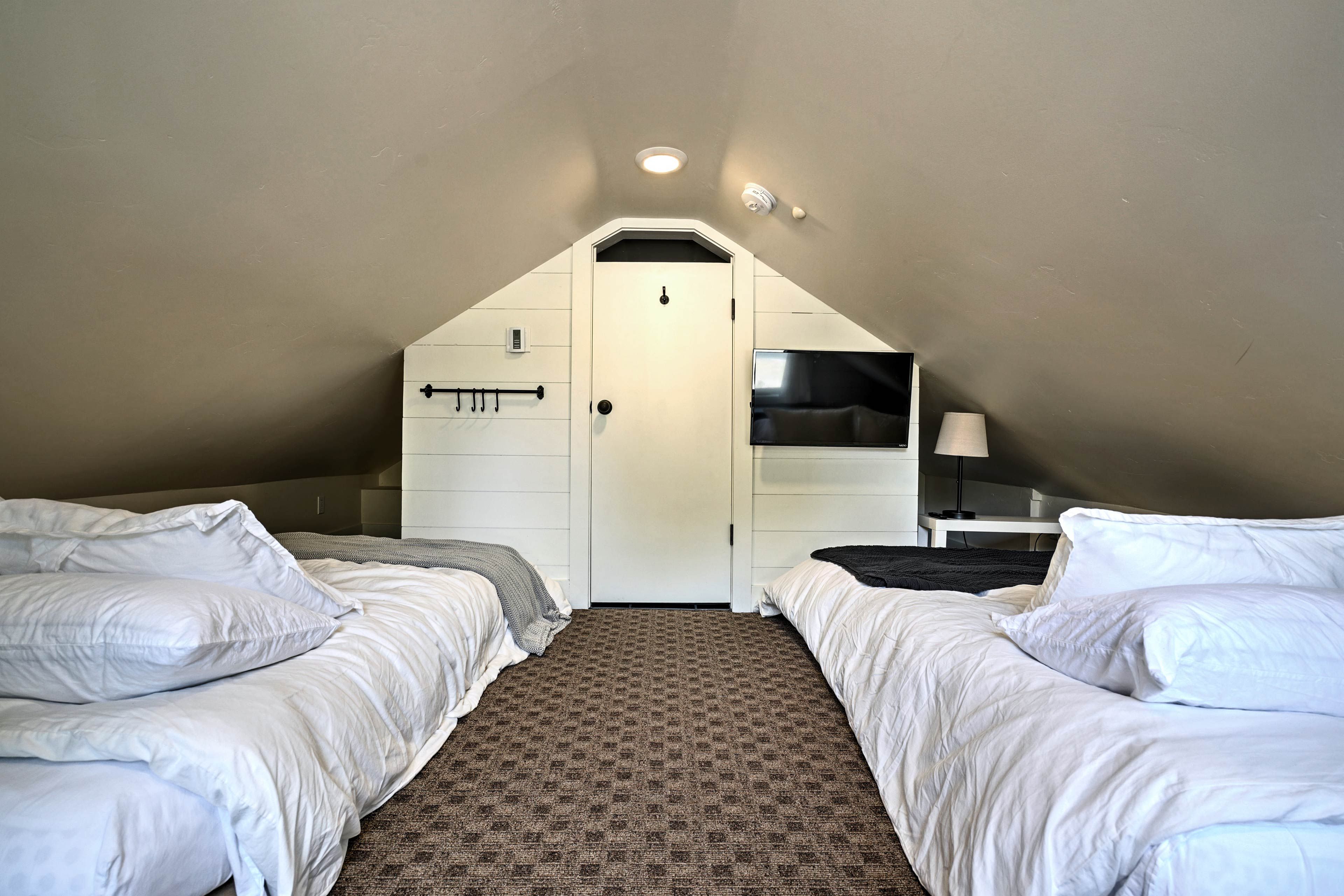 The loft bedroom boasts 2 queen beds and a flat-screen TV.