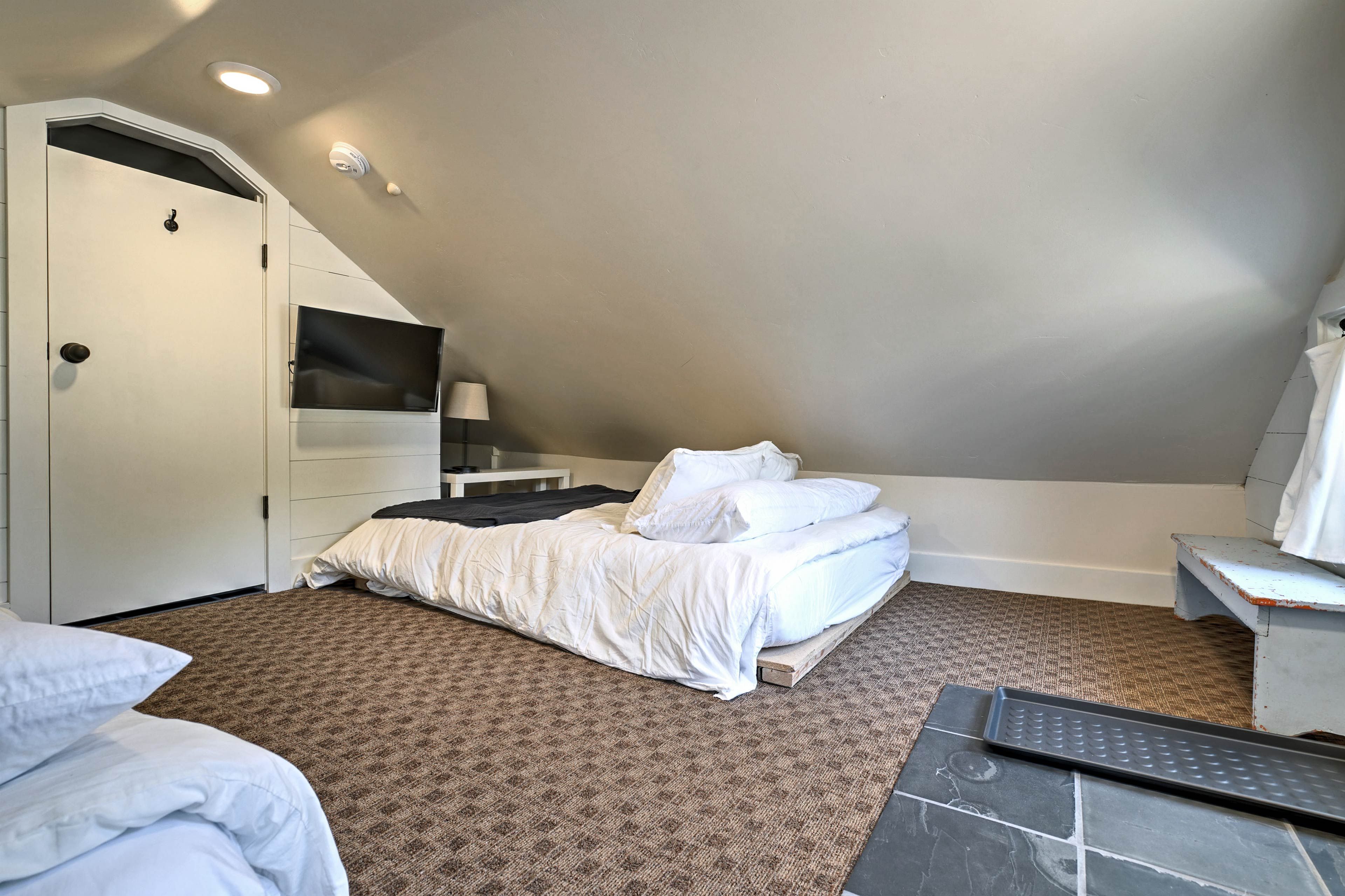 This bedroom has low ceilings, creating a cozy sleeping space.