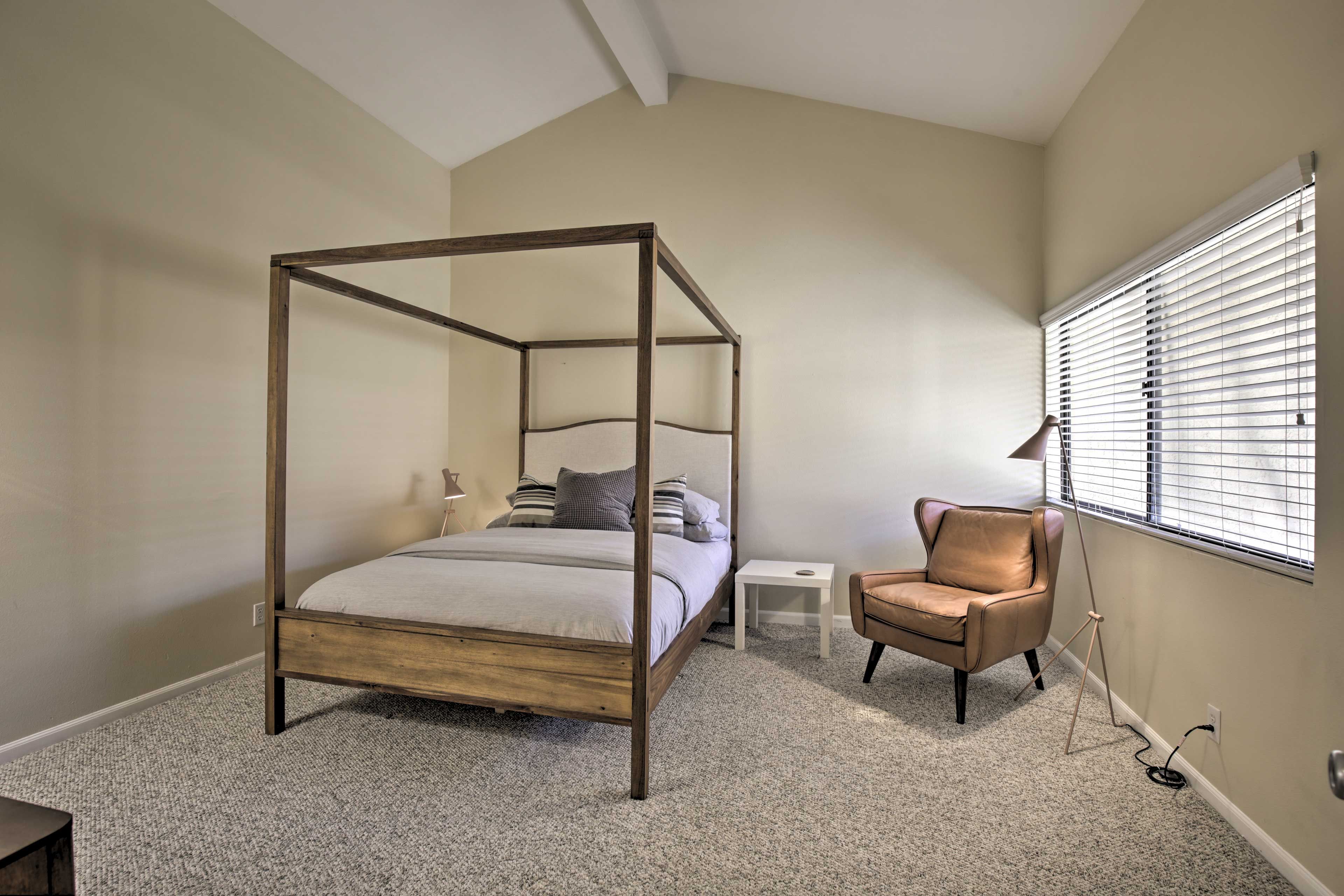 The bedroom suite boasts high ceilings and a queen bed.