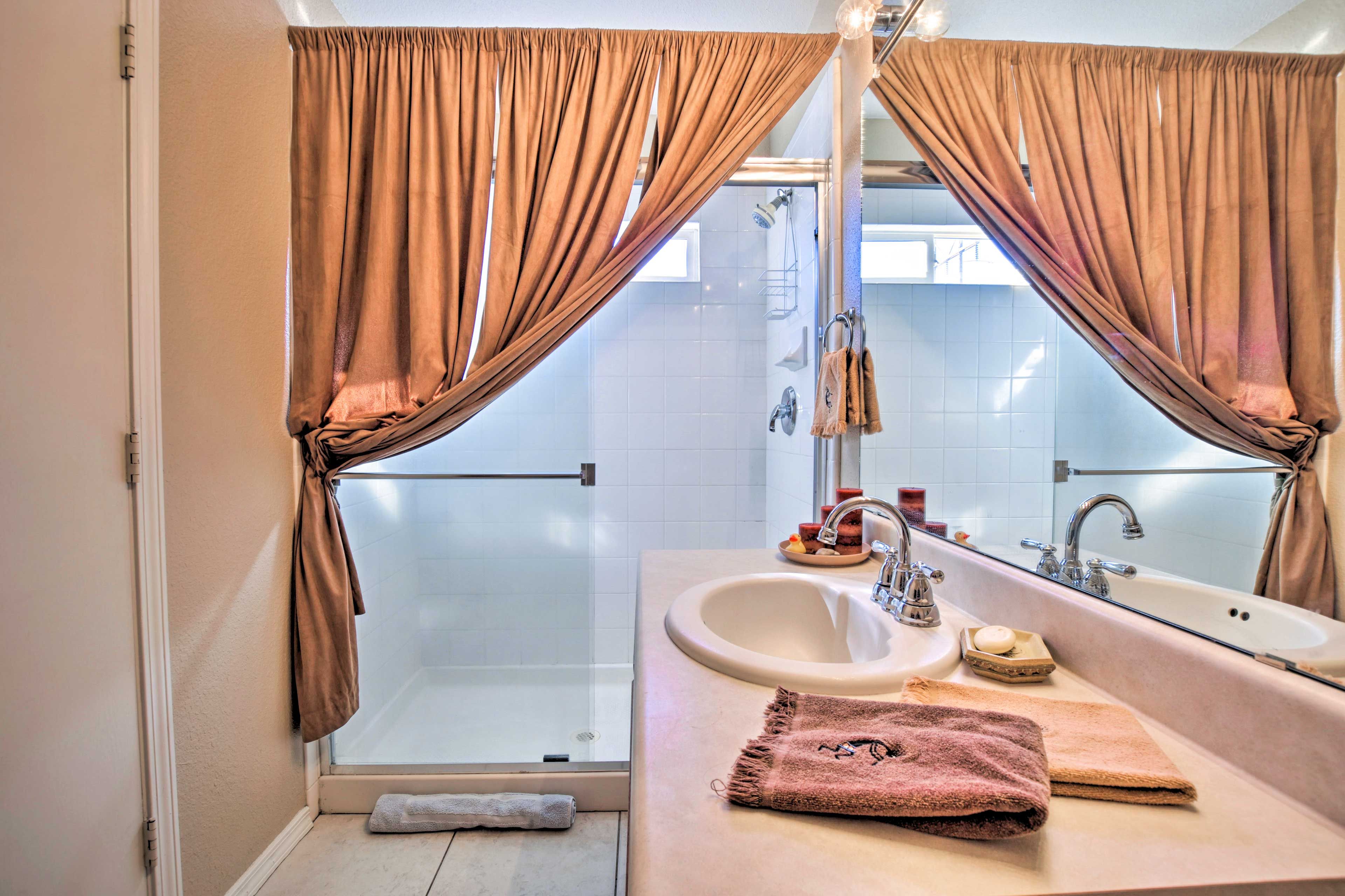 Rinse off in this walk-in shower boasting a lavish curtain.
