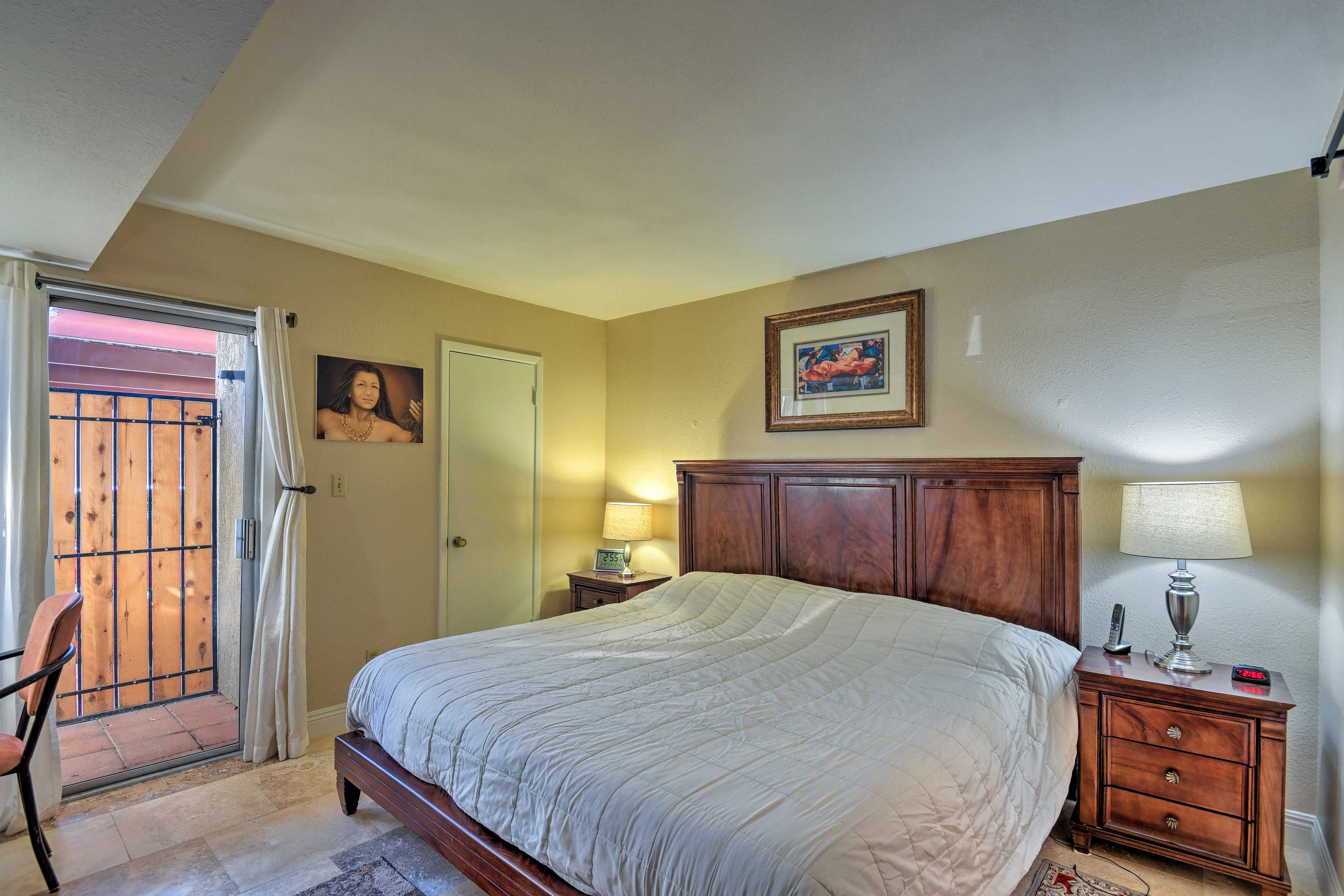 This bedroom features a king bed, patio access, and an en-suite bathroom.