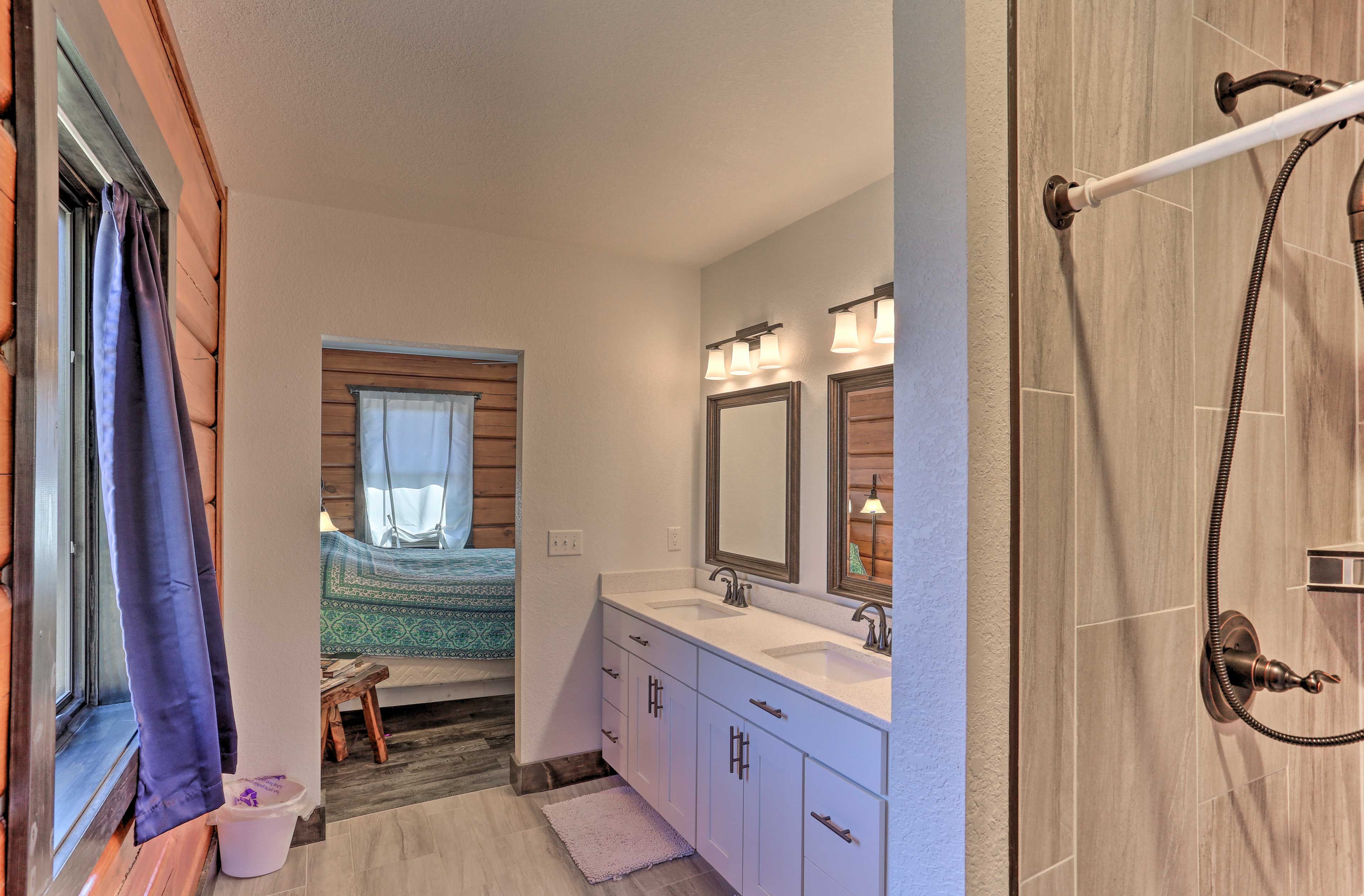 This full bathroom boasts double sinks and a shower.