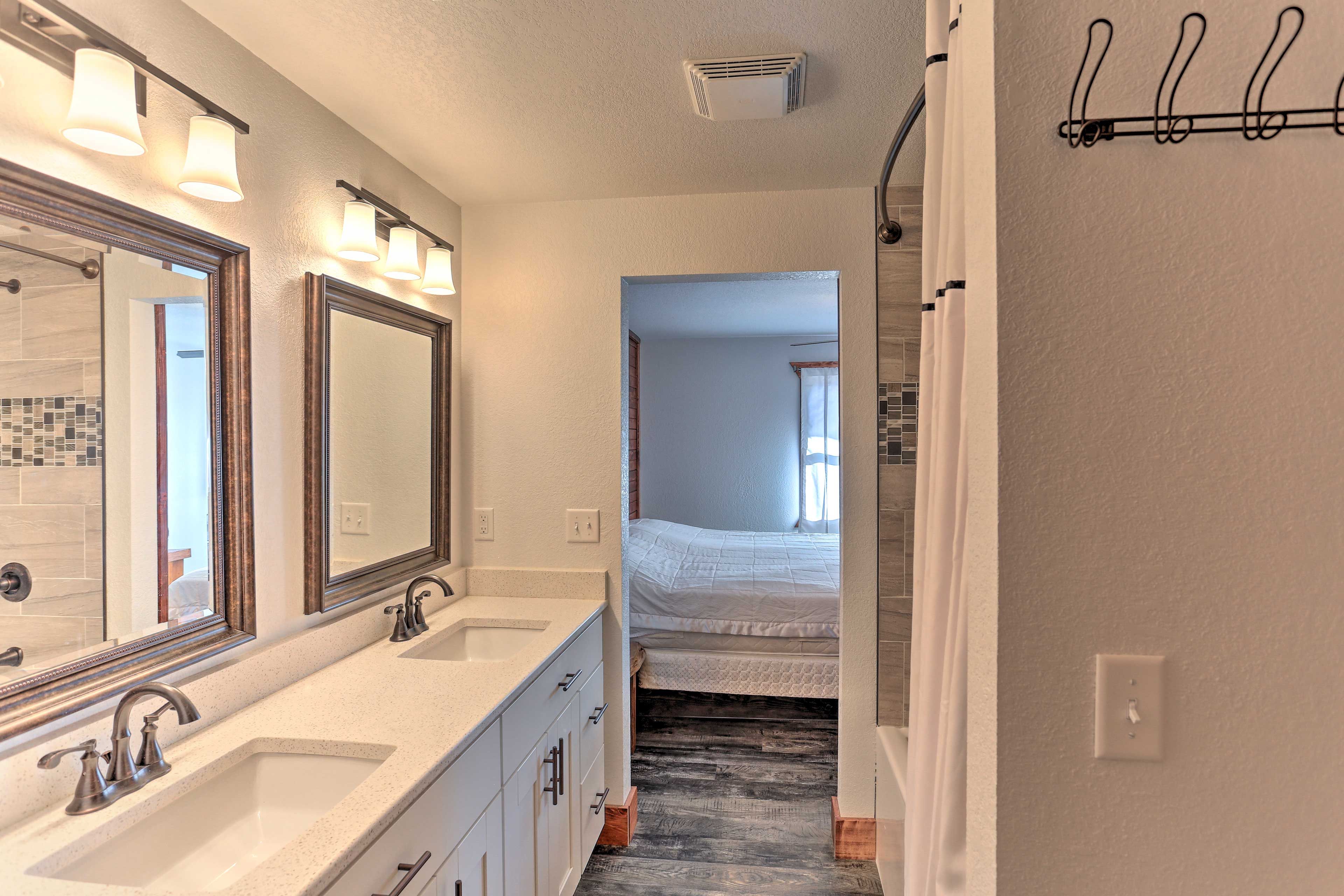 Upstairs, this sleek full bath hosts double sinks and a shower/tub combo.
