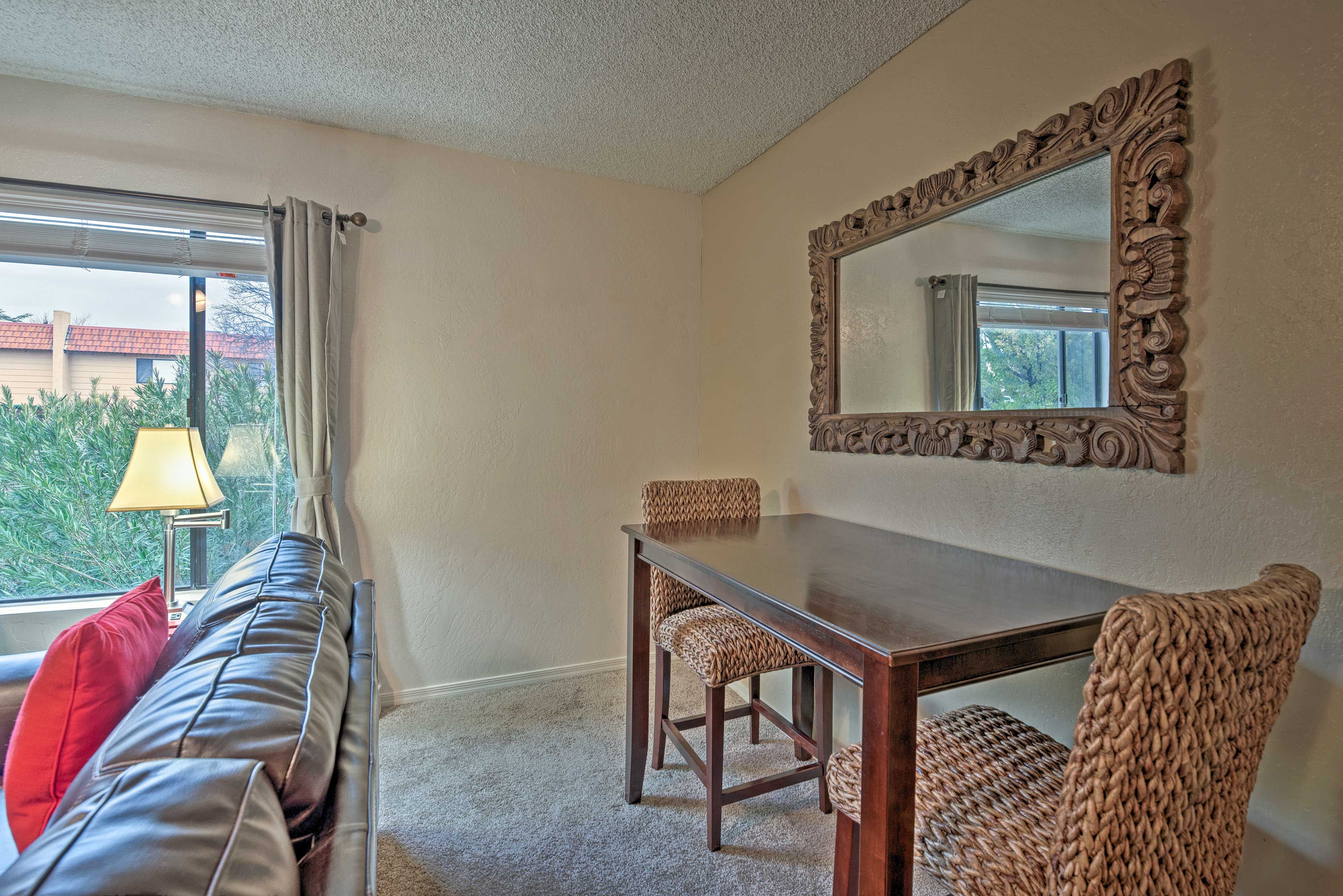 An antique mirror hangs above the 2-seat dining table.