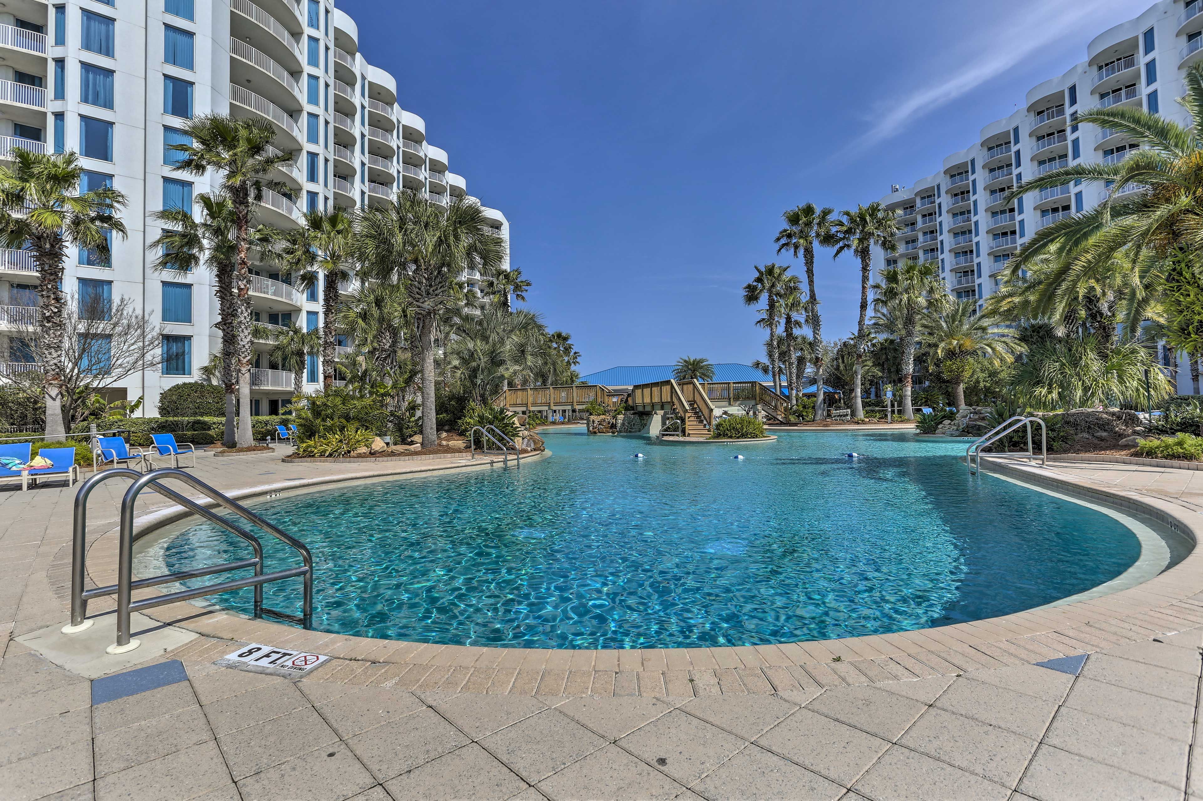 The pool is lined with towering palm trees, immersing you in the coastal vibe.