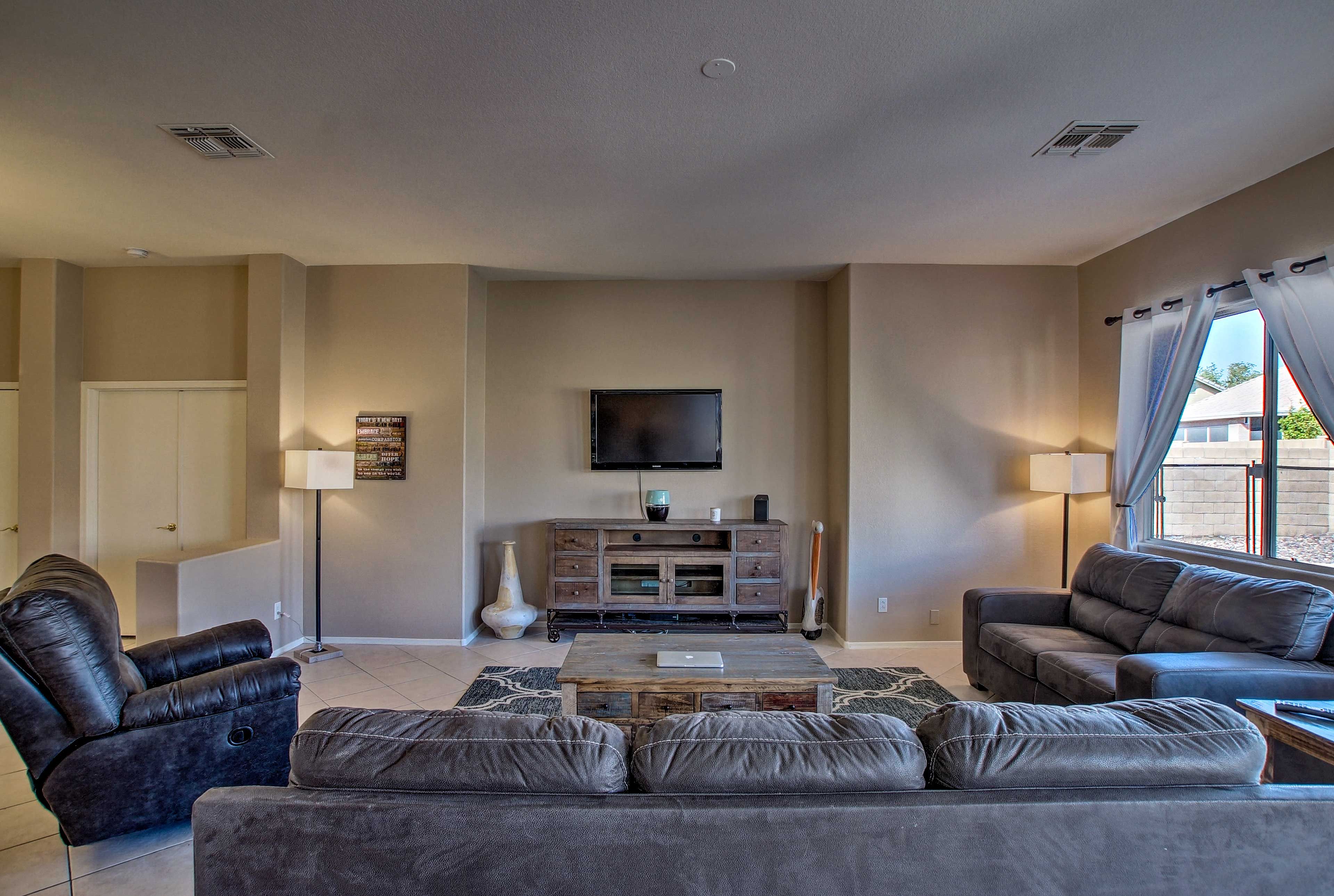 The spacious living area features a flat-screen TV and plush couches.