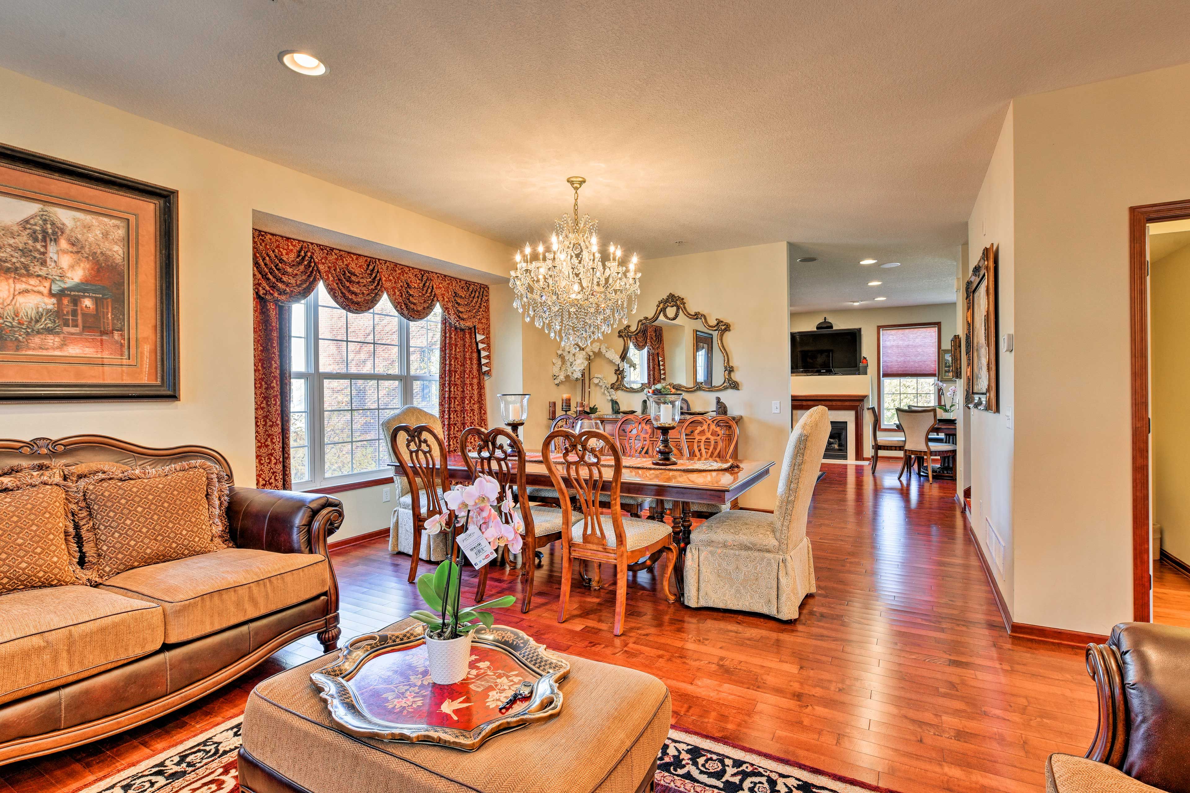 Dine at the large table, highlighted by a grand chandelier.