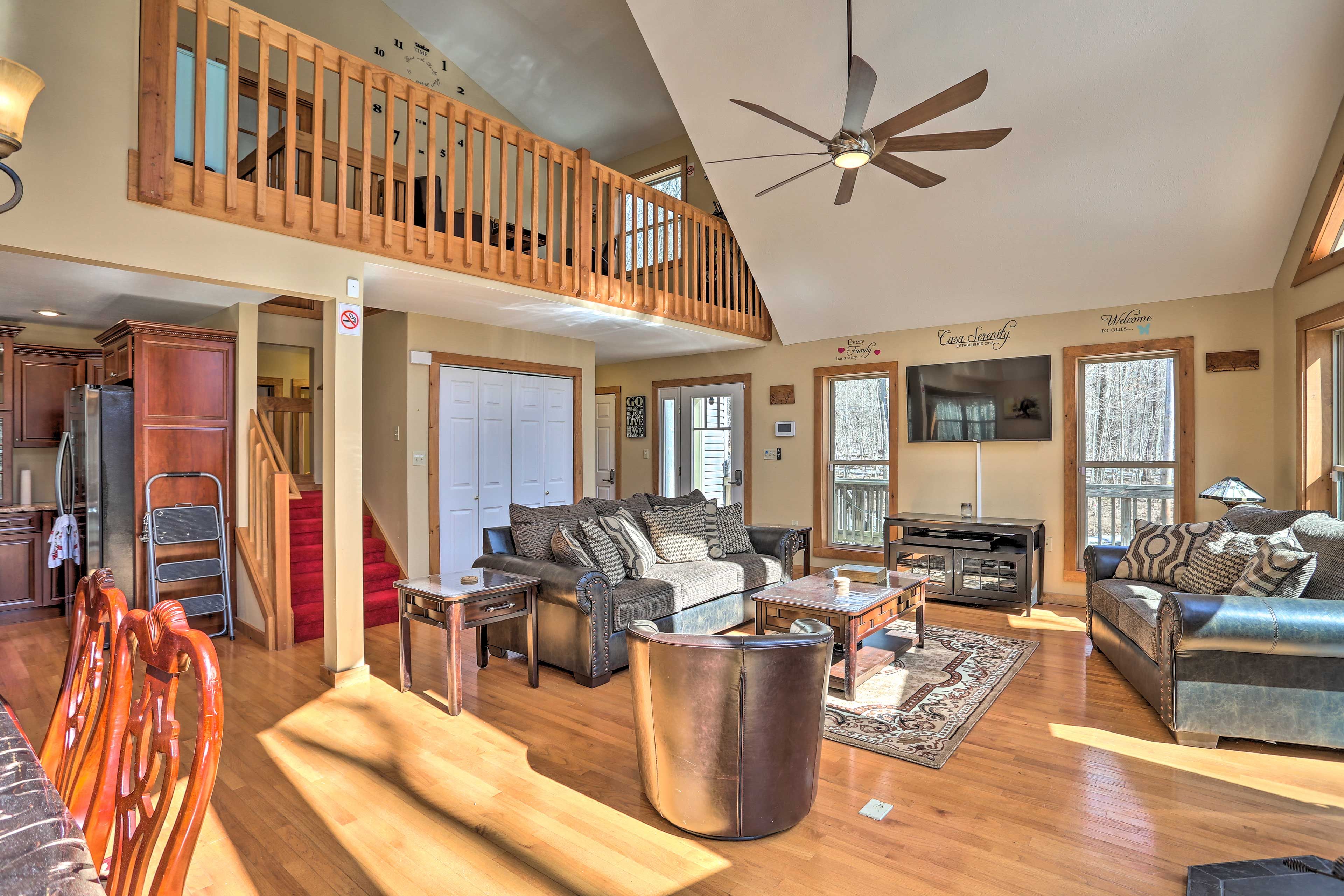 The spacious living area boasts cathedral ceilings and floor-to-ceiling windows.